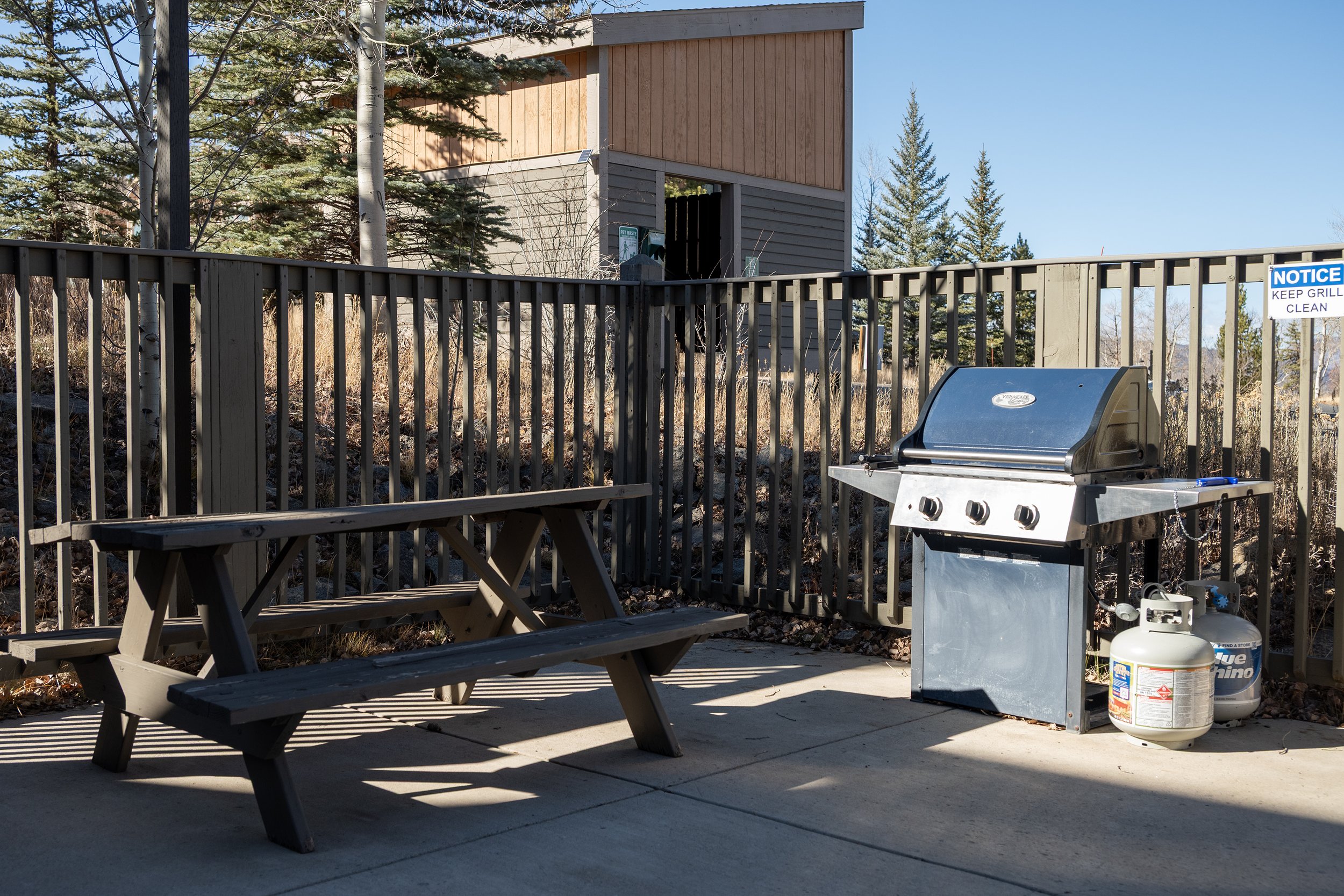 Shared outdoor grilling area with picnic table - just steps from the condo for easy alfresco meals.
