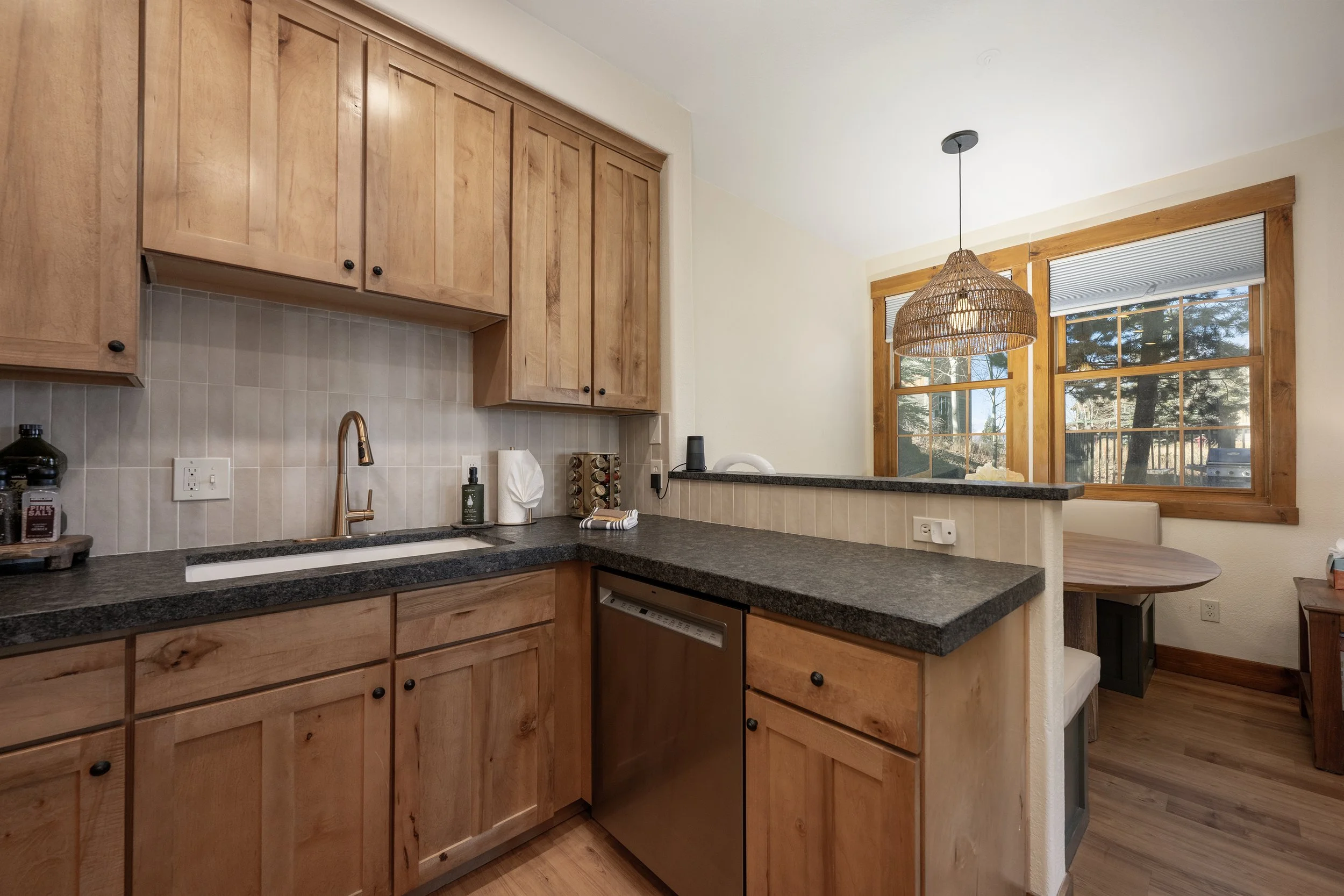 Bright, modern kitchen with ample counter space, new appliances, and a pass-through window overlooking the cozy dining nook.