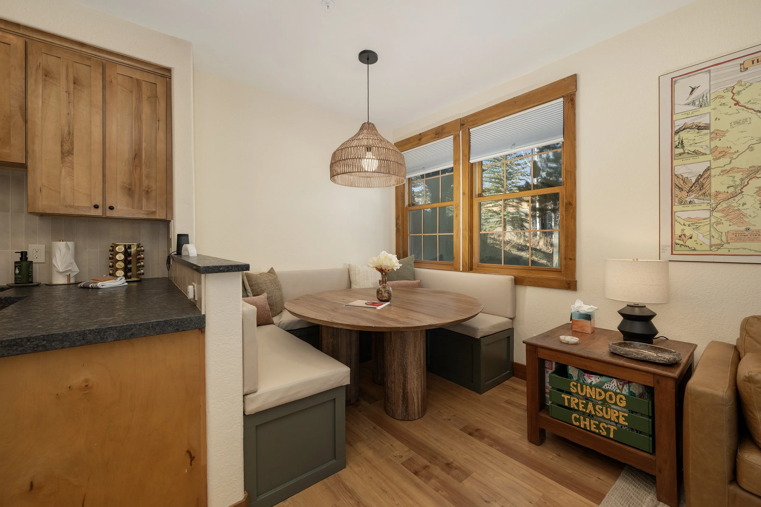 Cozy dining nook with custom bench seating, a round wood table, and warm natural light ... perfect for meals, games, or planning your mountain adventures.