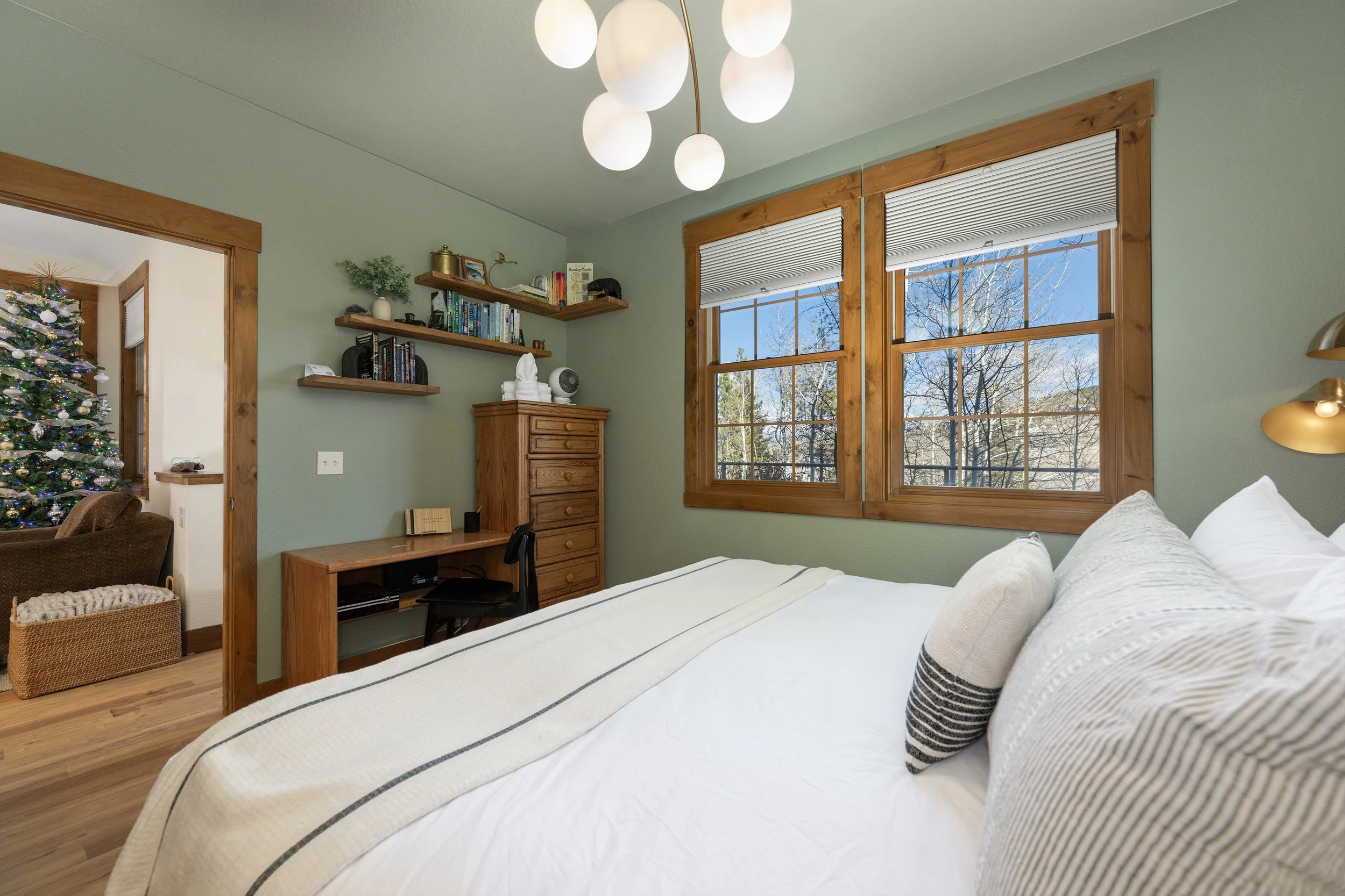 Cozy king bedroom with warm wood trim, mountain views, and a dedicated workspace...perfect for relaxing or working remotely.
