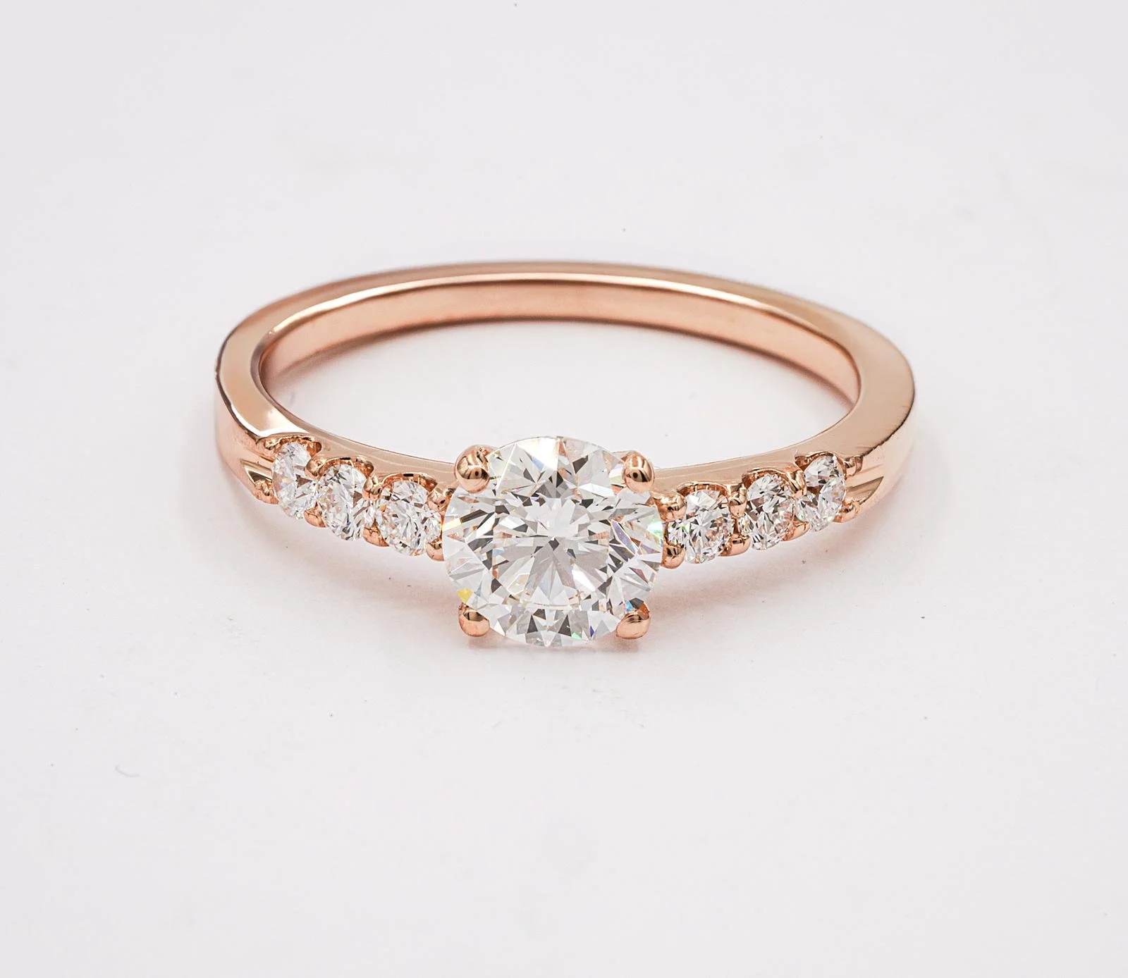 Goldene Verlobungsring mit großem zentralem Diamanten und kleineren Diamanten an den Seiten