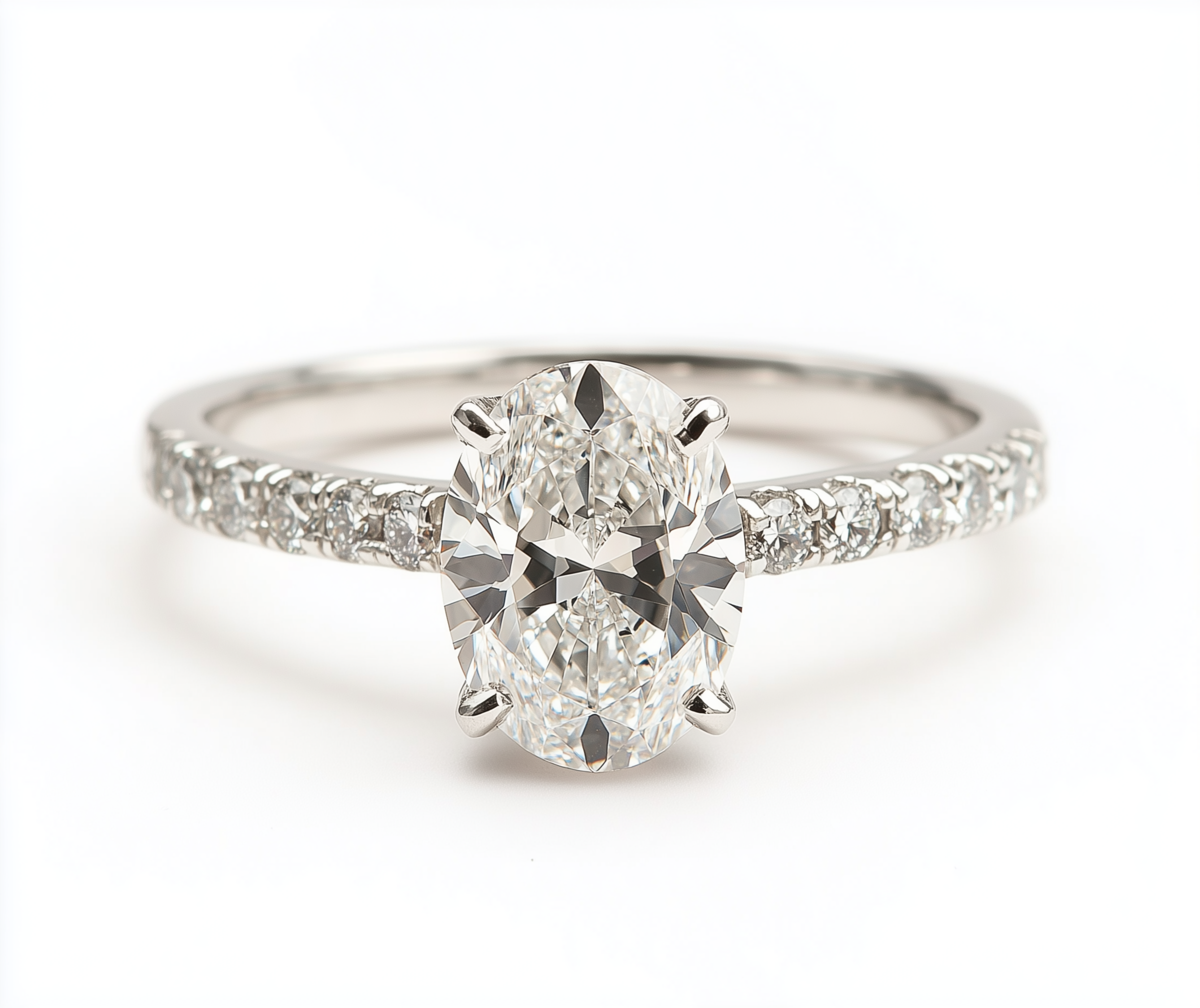 Ein Verlobungsring mit einem großen, runden Diamanten in einer Prong-Fassung, umgeben von kleineren Diamanten im Schleifen-Design auf einem weißen Hintergrund.