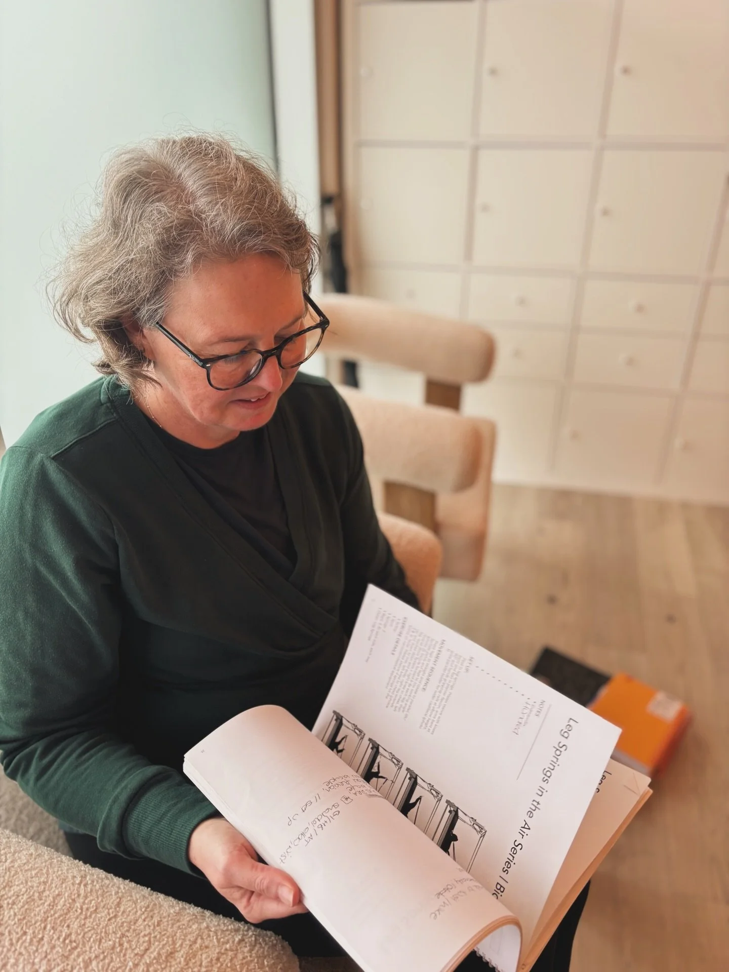 Charlotte sits in the very studio where she once walked in as a client, then a student &mdash; now, as a apprentice teacher, her hands rest on the manual that&rsquo;s become both guide and companion.

It&rsquo;s not about just flipping pages.
Its abo