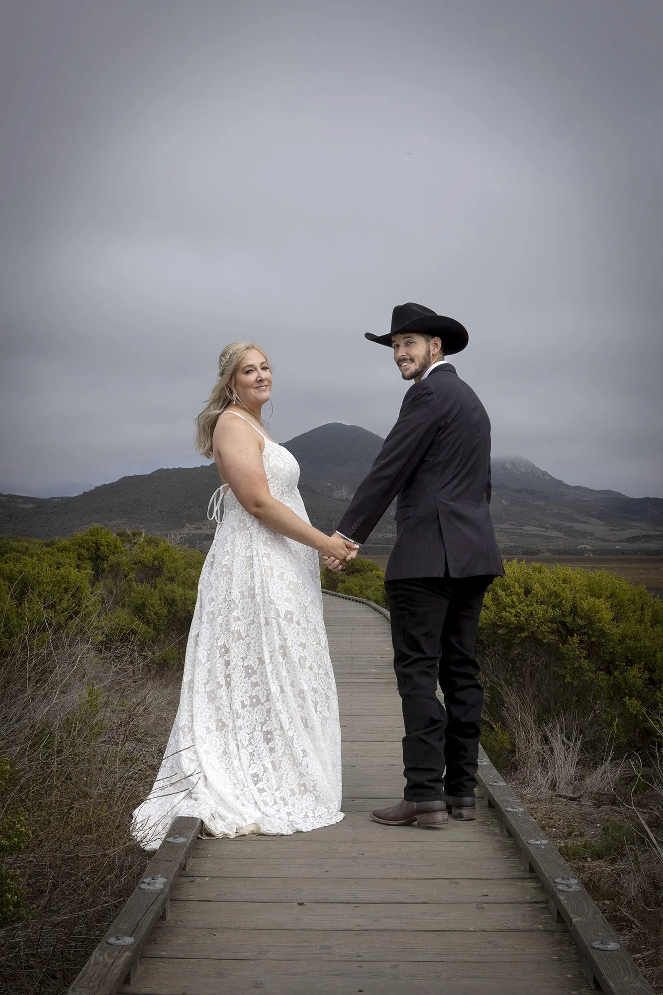 Bride and groom walking on Morro Bay State Park boardwalk