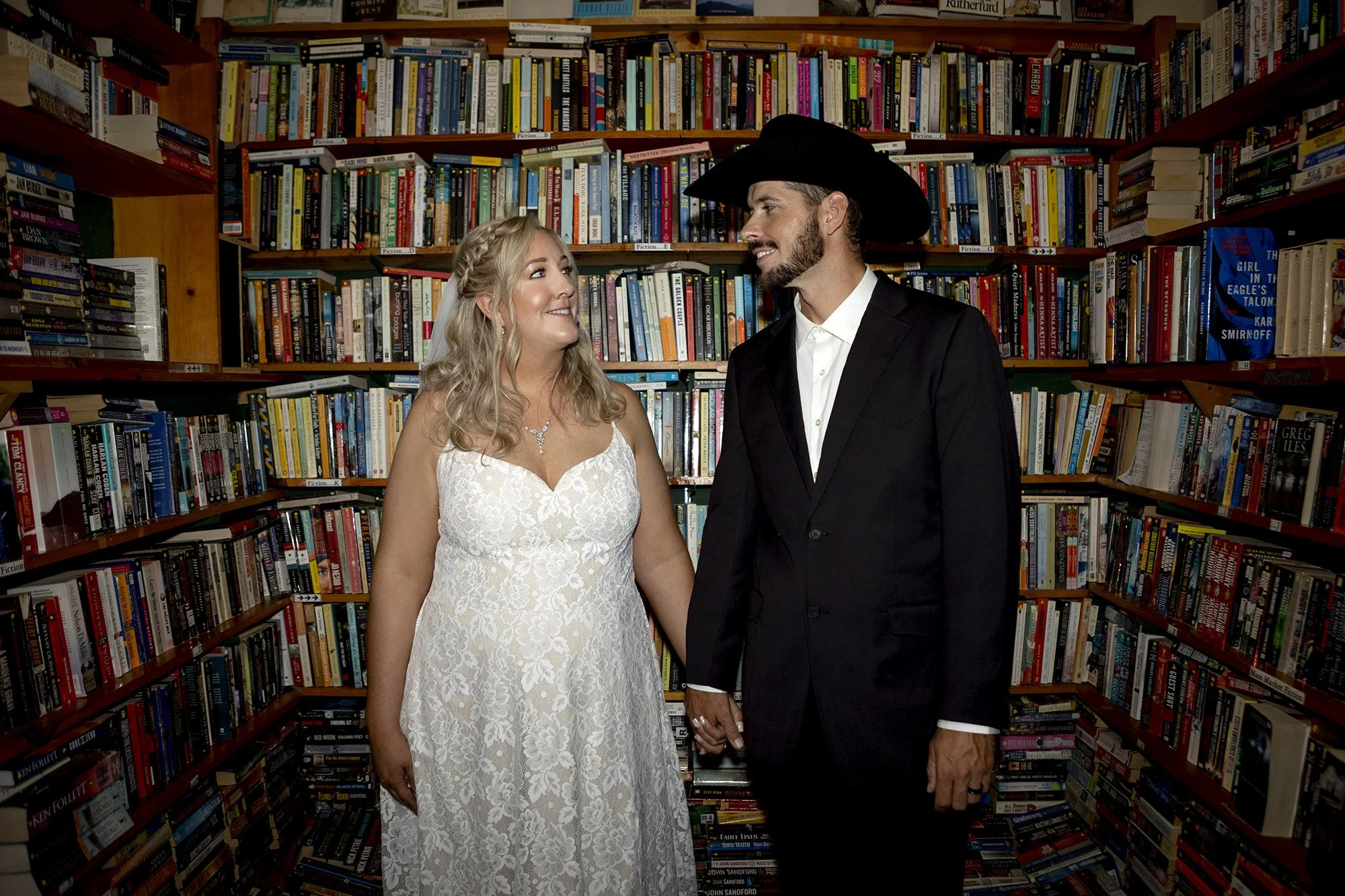 Bride and groom portraits inside Coalesce Bookstore surrounded by books