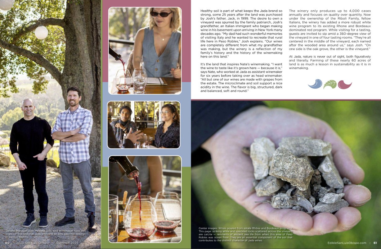 A man and woman standing outdoors under a large tree, smiling at the camera.
