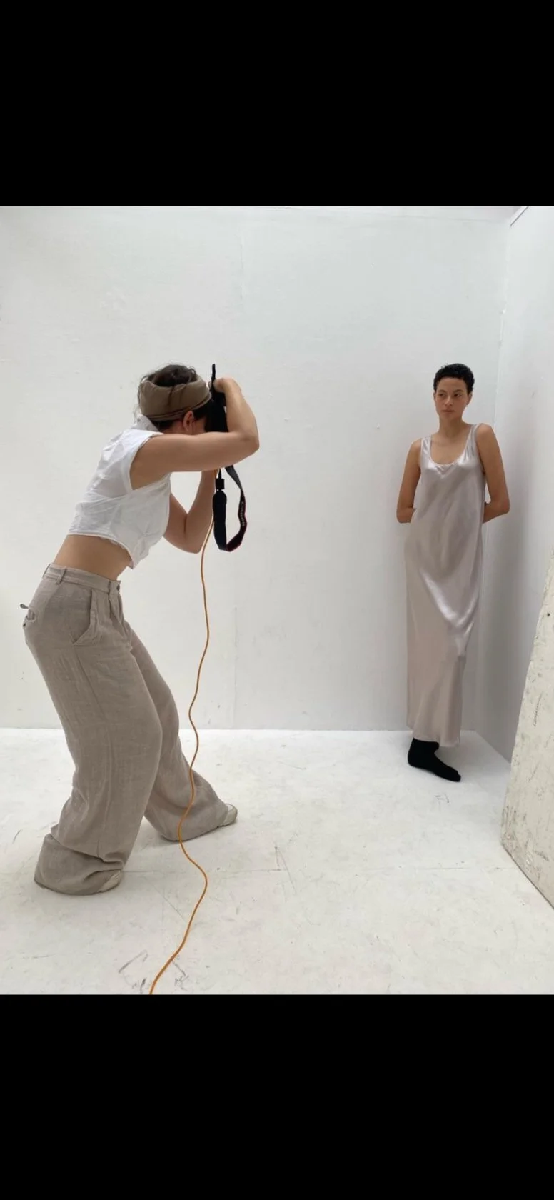 Photographer taking picture of a woman in a white room