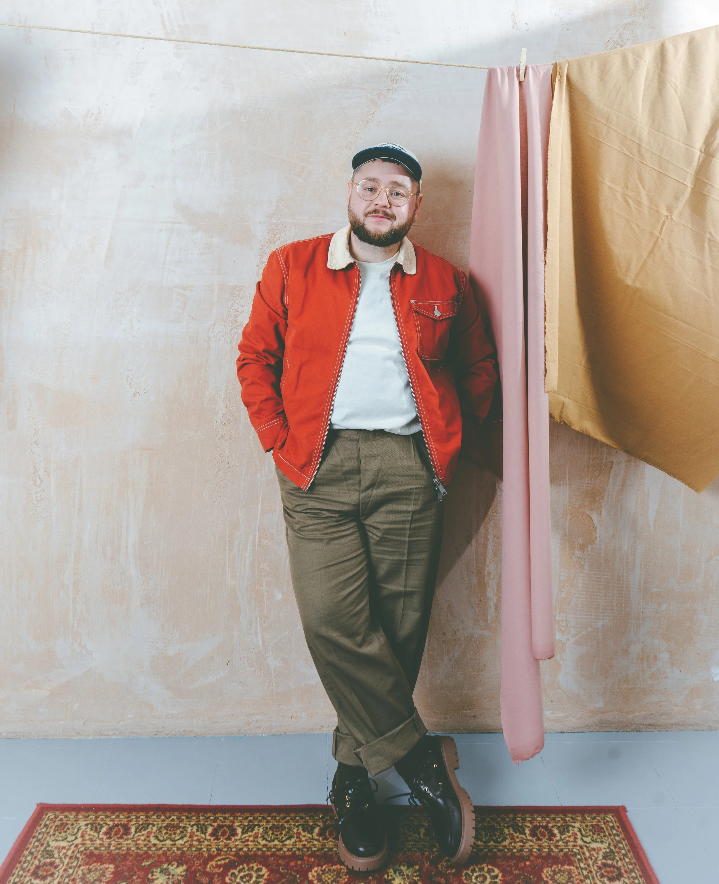 Raggi Wears: Jacket - Wax, Trousers - All saints, shoes - Stylist own, Hat & T - Artists own