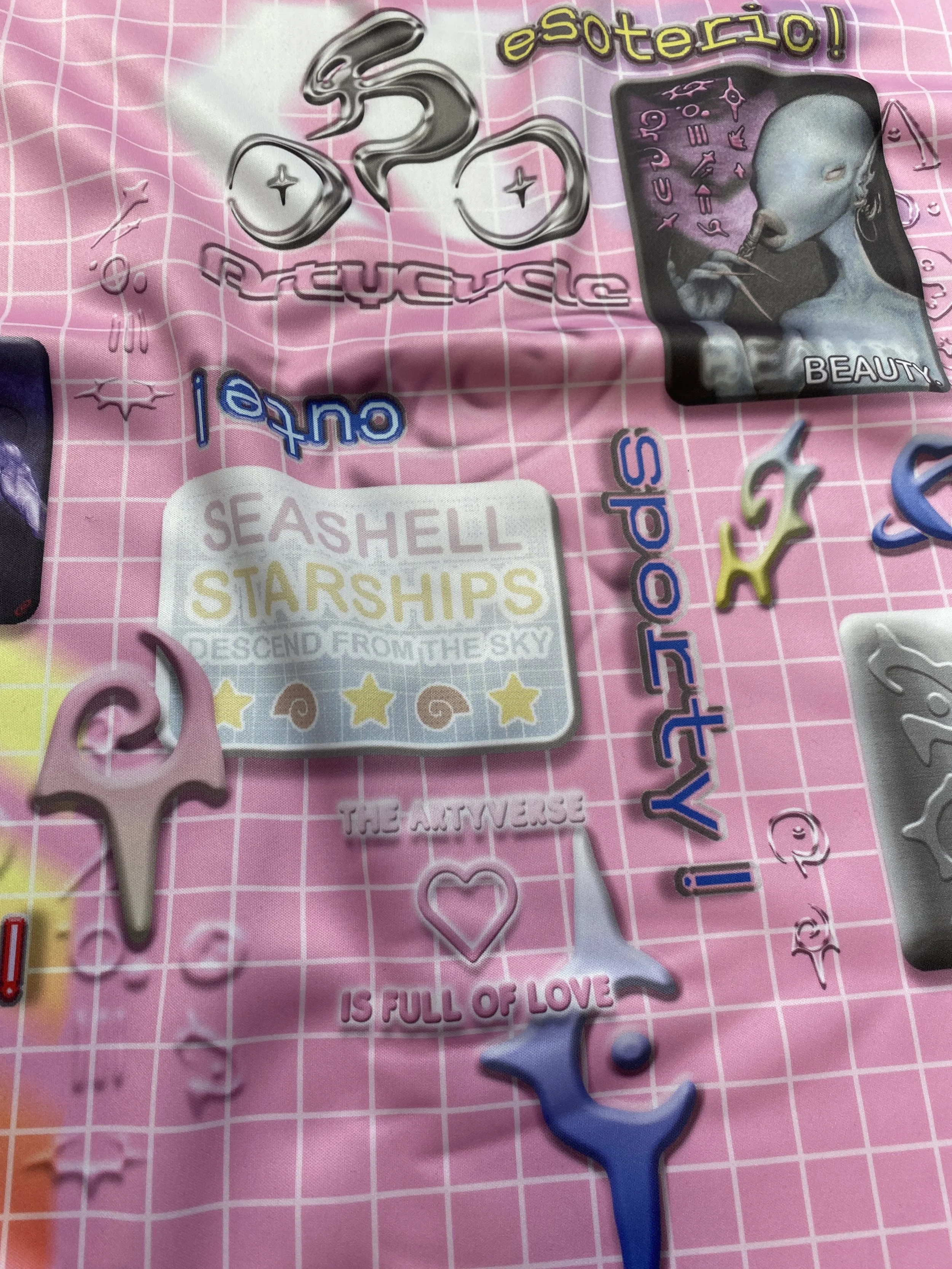 Abstract art collage with a pink grid background featuring futuristic designs, text saying "SEA SHELL STARSHIPS," "The Artiverse is full of love," and other words like "esoteric," "outro," and "sporty." It includes various shapes, stars, and an alien