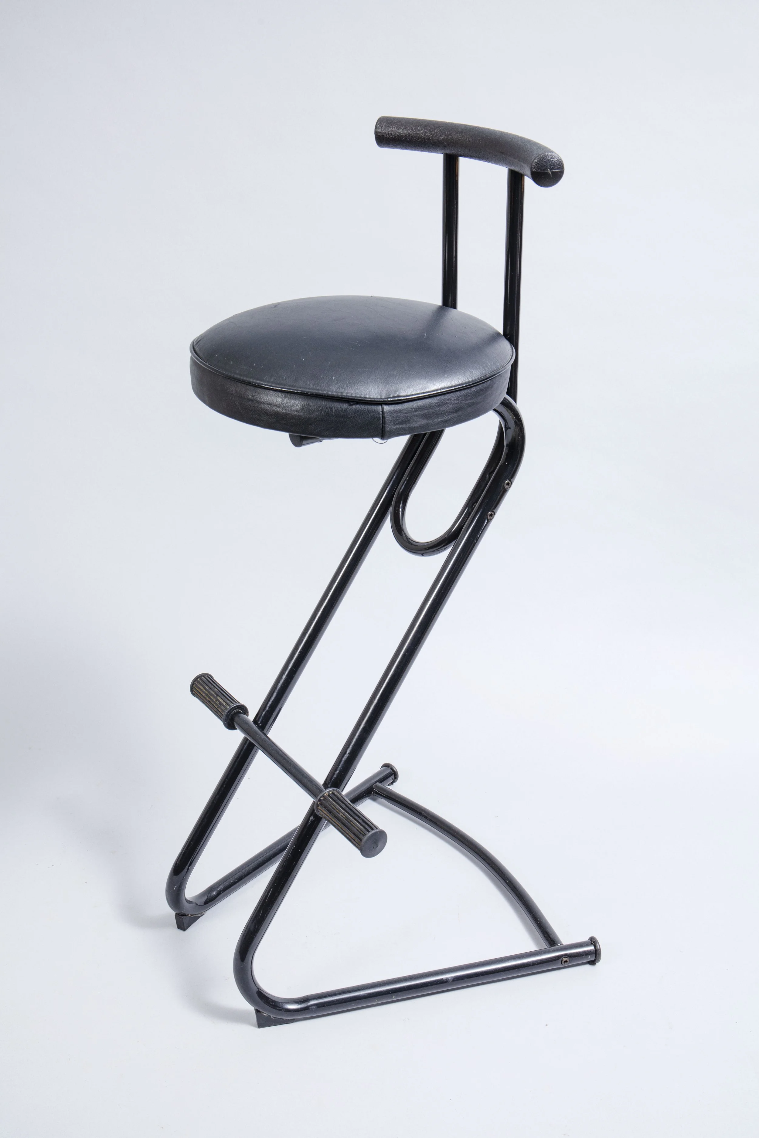 A pair of tall 1980s stools made of metal and faux leather