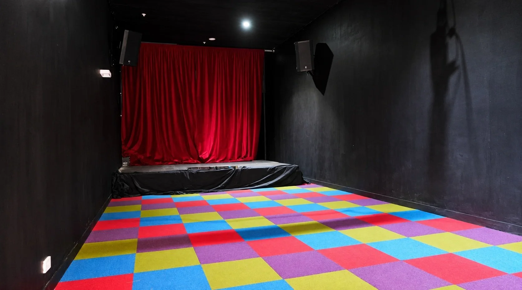 The Pit Theatre, an open-floor event space with a small stage, at The Improv Pit in Collingwood
