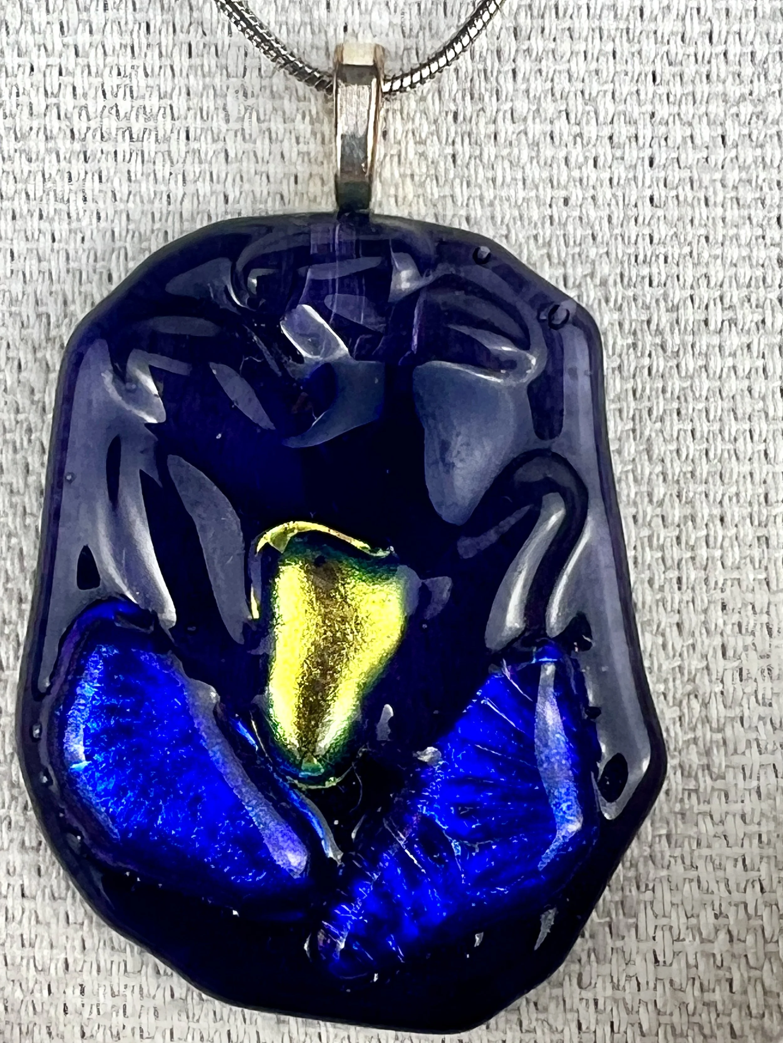Dichro Bloom Collection blue fused glass necklace worn on mannequin