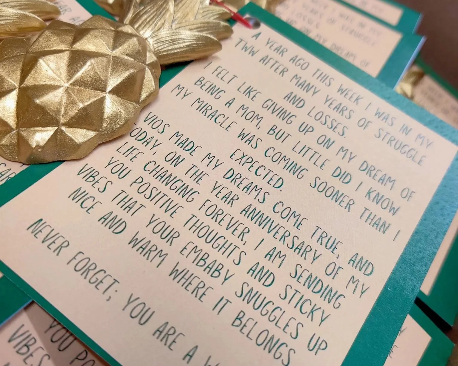 A handwritten note on a colorful background, with gold pineapple decorations placed on top. The note is a heartfelt message reflecting on personal growth and positive change.