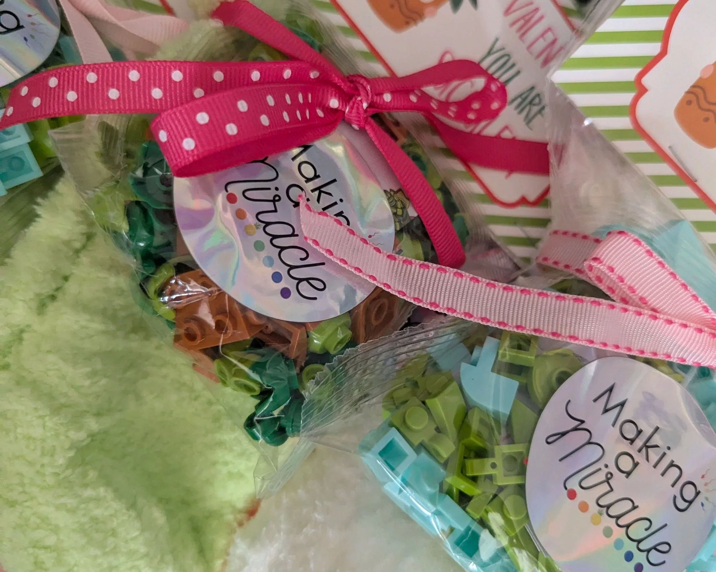 Close-up of a colorful, decorated Easter gift bag with pink polka dot ribbons, pastel decor, and a label that says "Spring".