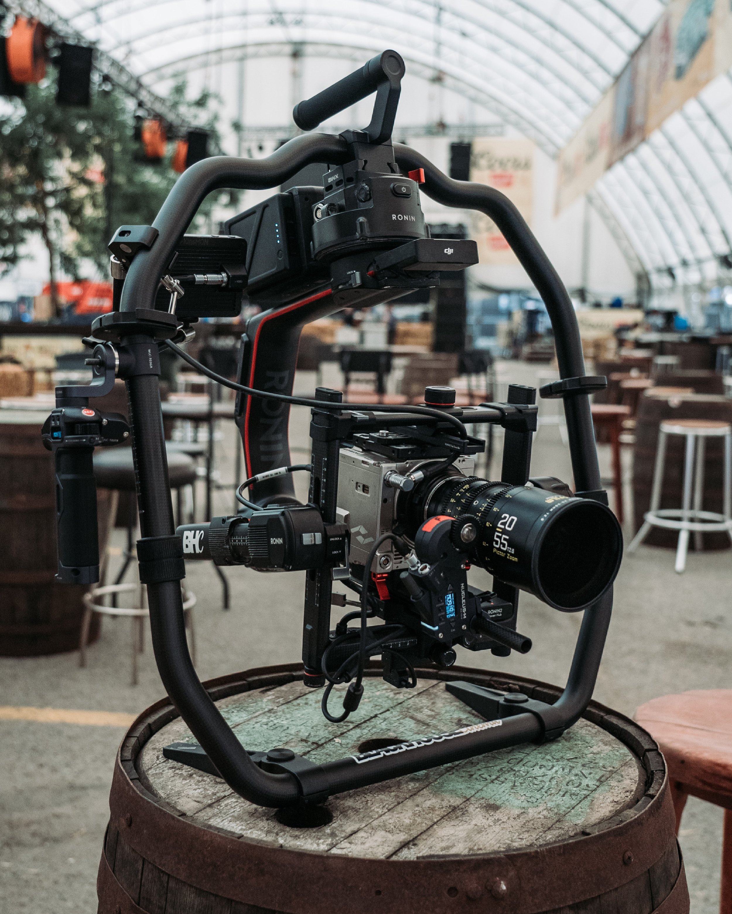 Professional camera on gimbal stabilizer mounted on barrel in indoor setting.