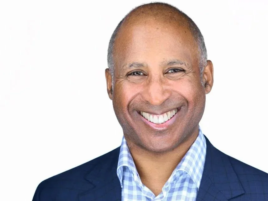 Executive headshot of an older male professional in a navy suit and tie with a composed, trustworthy expression – Brand Savage corporate headshots