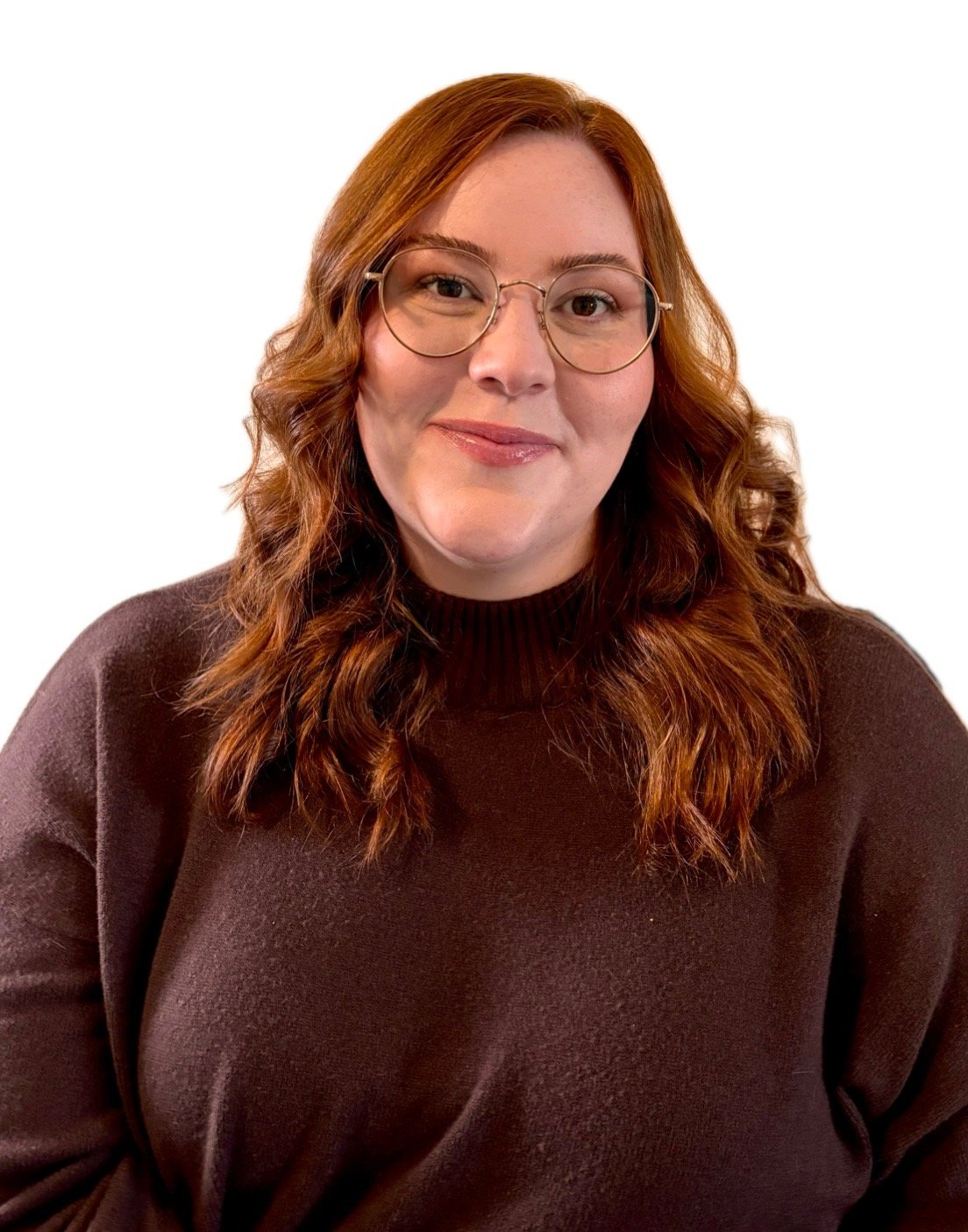 Person with long red hair and glasses, wearing a dark brown sweater, smiling.