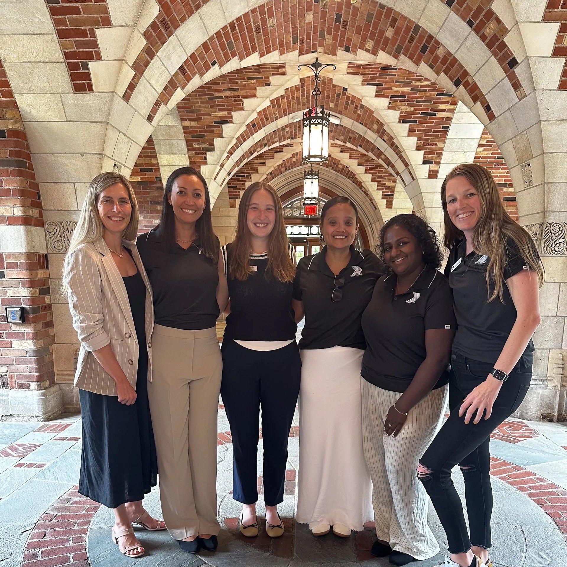 Group image of 6 women in a historic hallway at Yale University