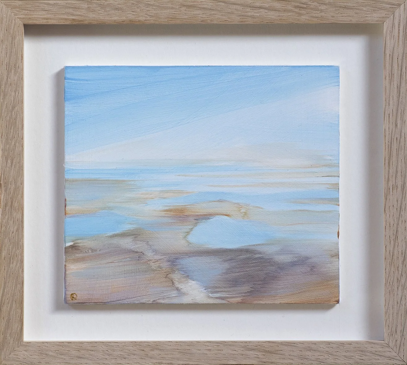 Painting of a coastal seascape with blue sky, calm ocean, and sandy shore, framed in a light wood frame.