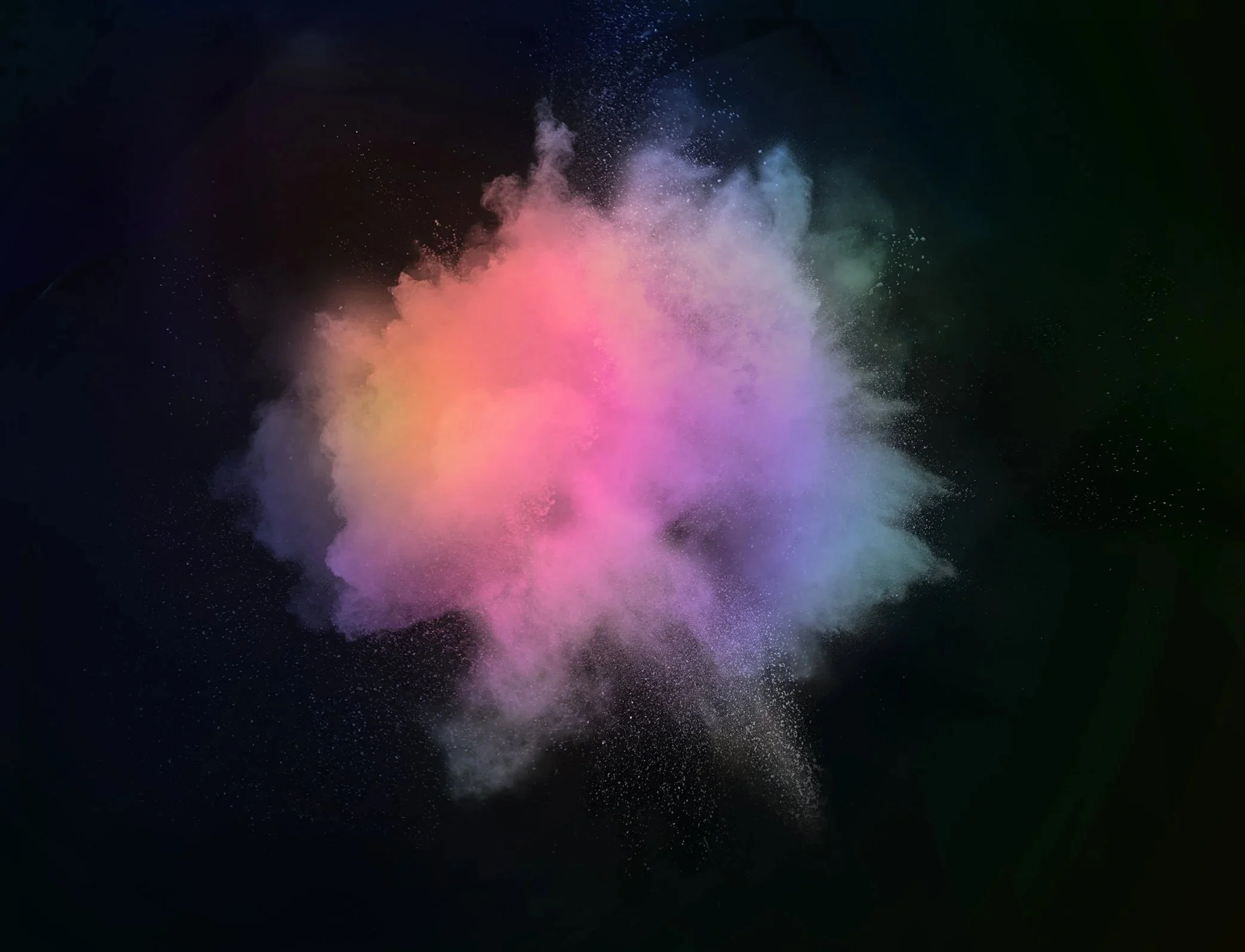 Colorful powder explosion in dark background creating a cloud of pink, purple, yellow, and green hues.