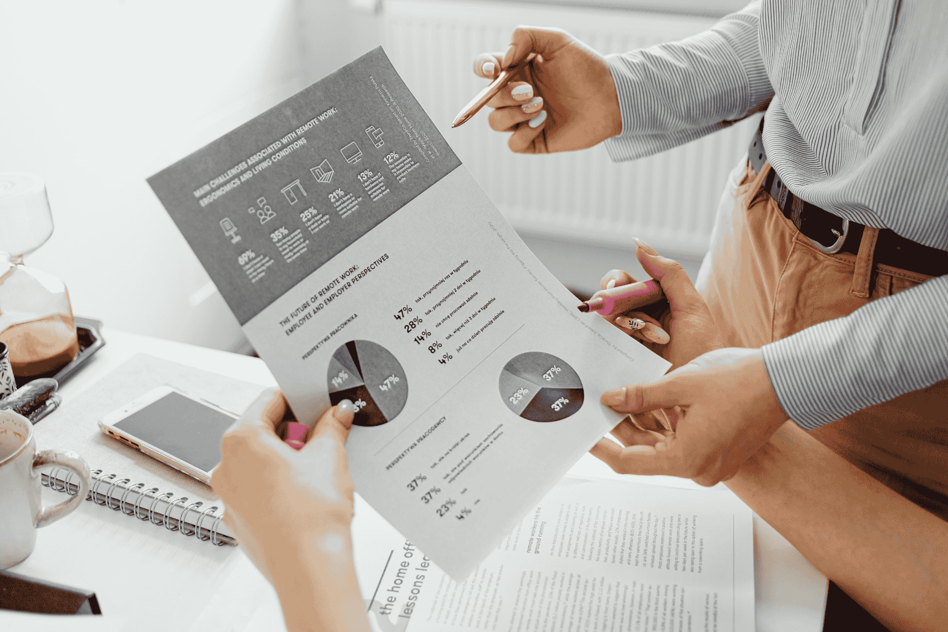 A man and a woman looking at a paper with a chart and graphs showing analytics in business.