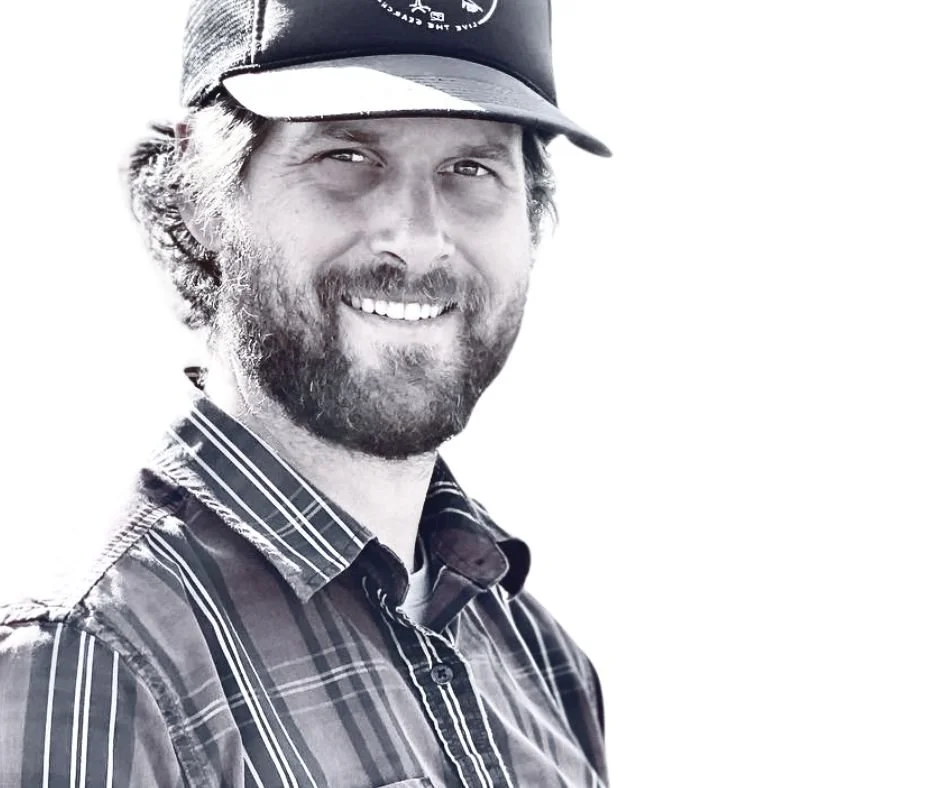 Image of a man with a beard, wearing a trucker hat and button up plaid shirt with a smile showing he is a casual professional with confidence to help other businesses do well online.