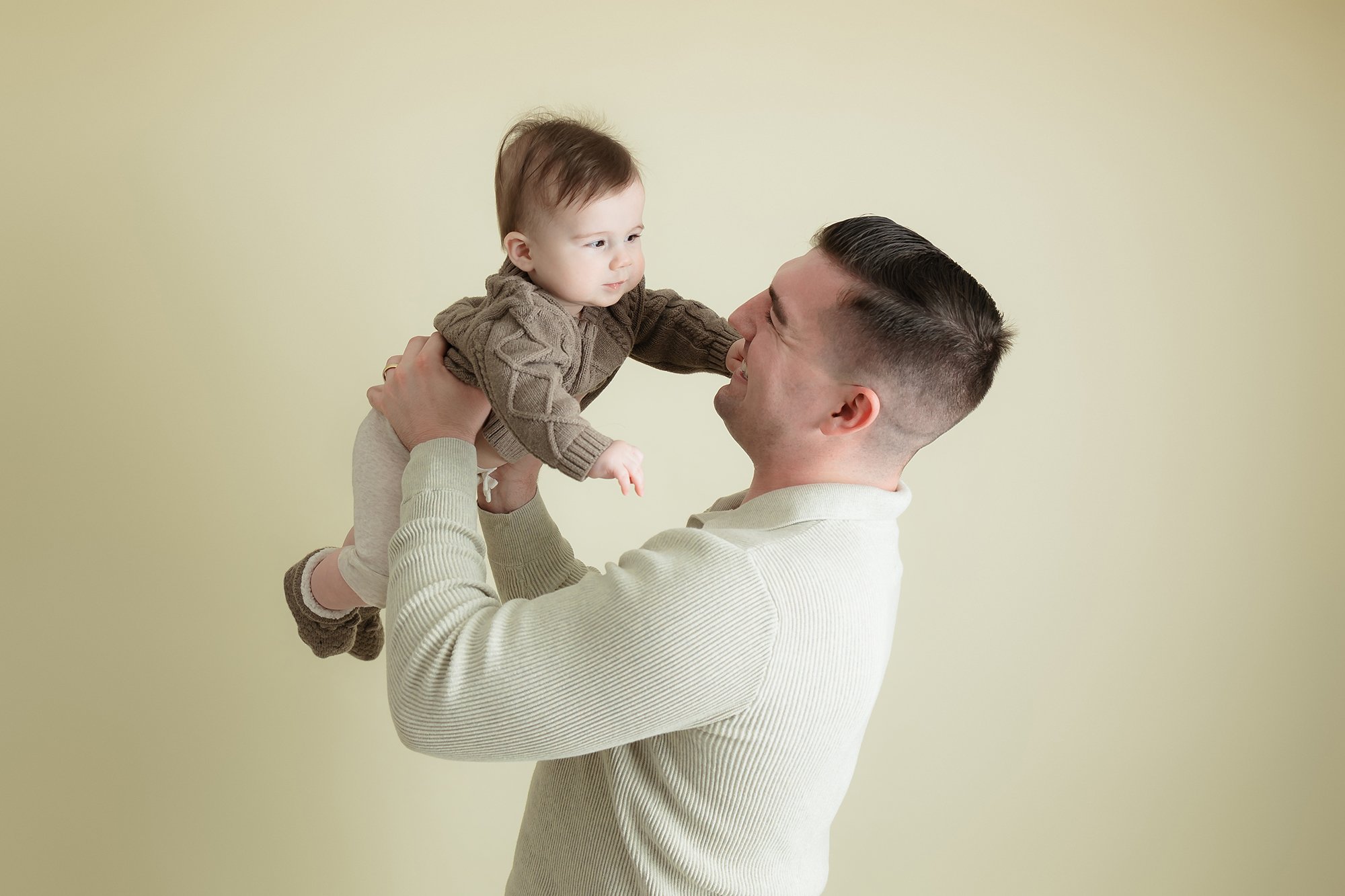 Father and 6 month old son posing for their family portraits.