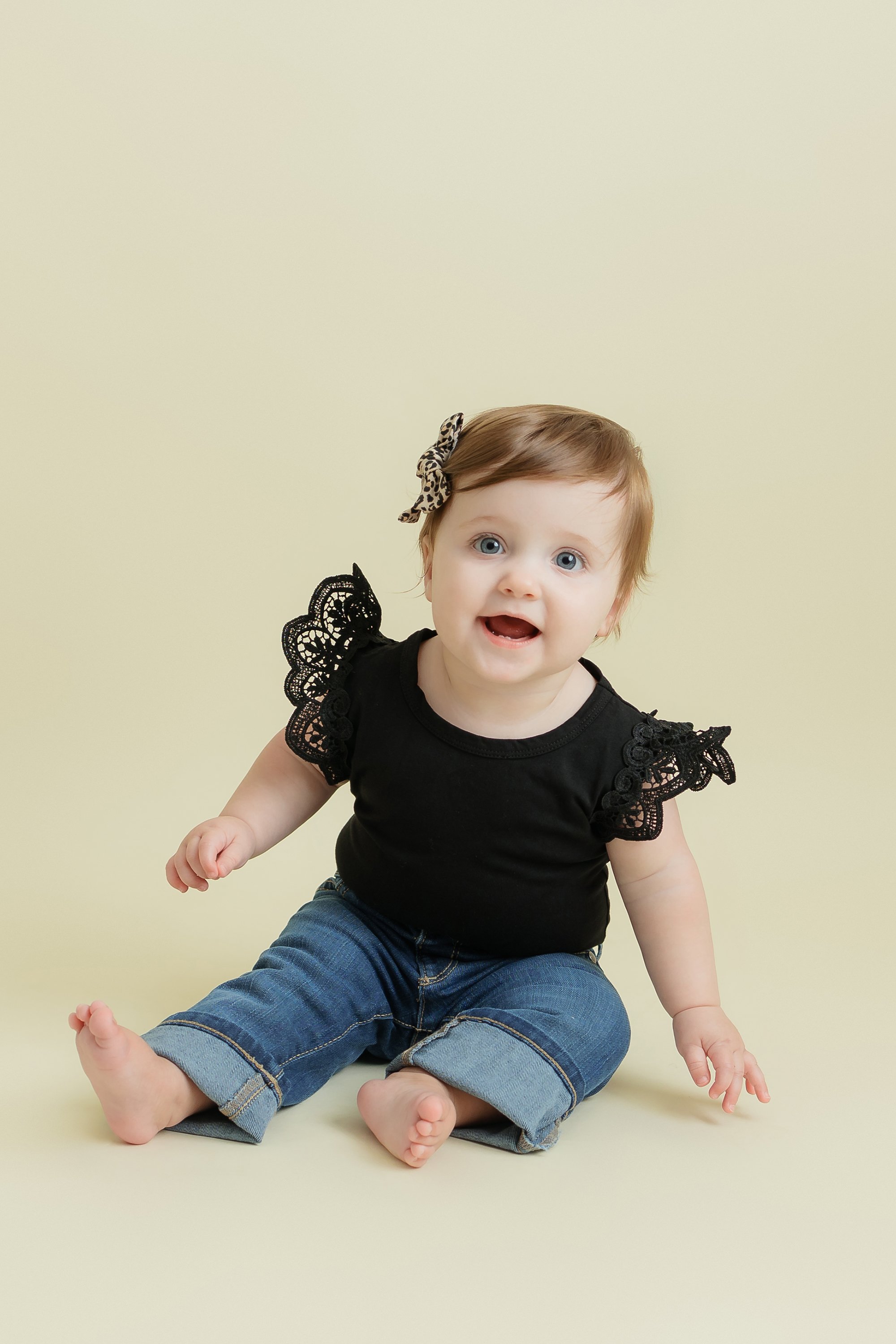 One year old girl sitting and posing for her portrait session.