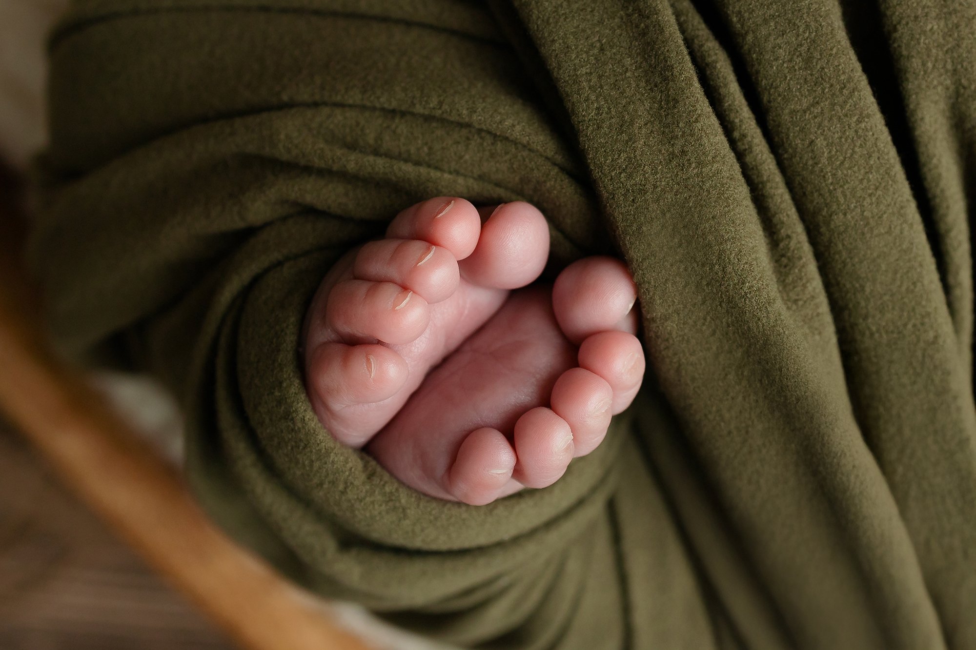 A close-up of a newborn baby’s wrinkled feet and tiny toes, highlighting the pure essence of a new beginning.