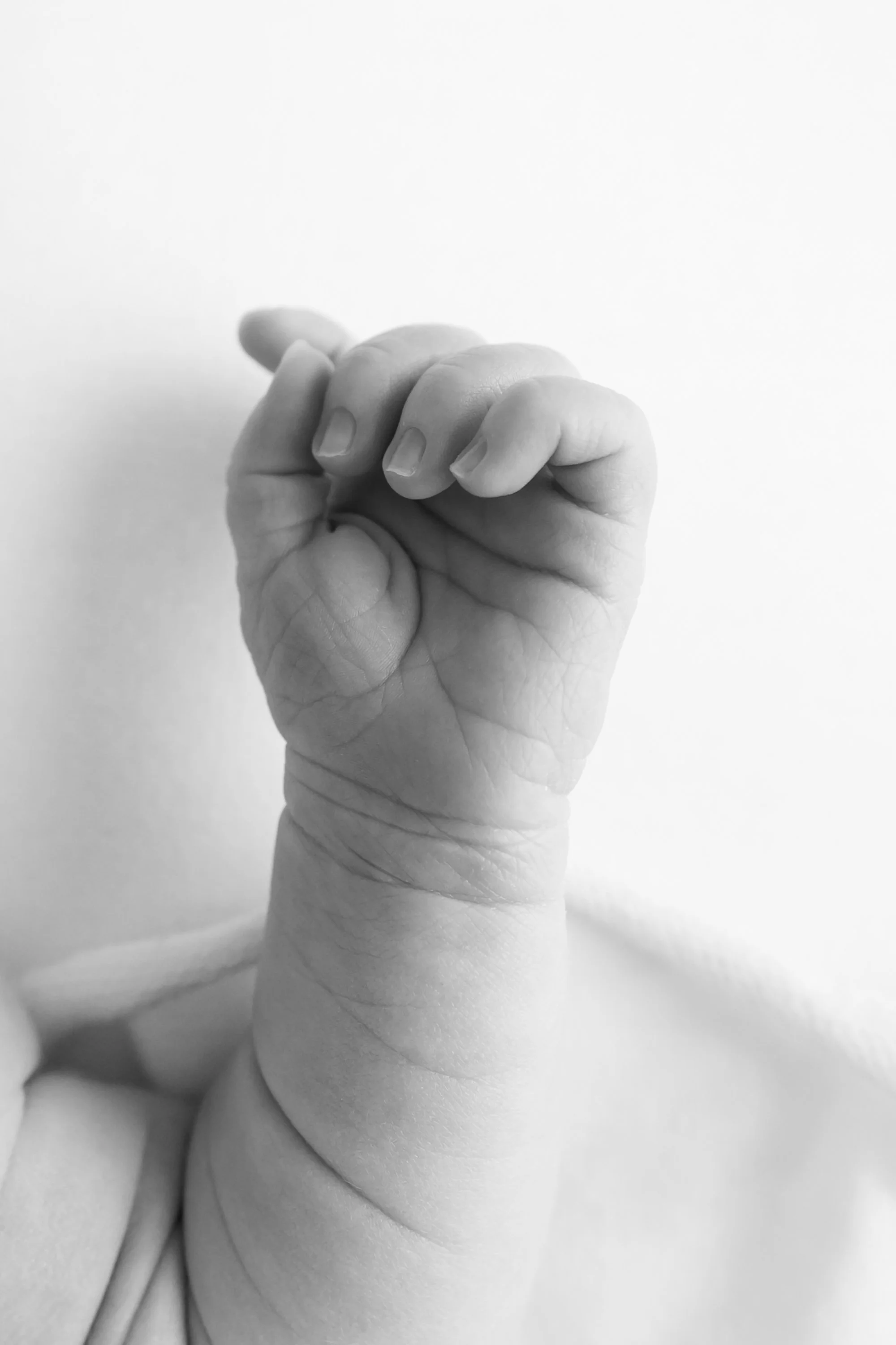 A macro photograph highlighting a newborn baby's delicate features, showcasing their tiny eyelashes, soft cheeks, and little lips while sleeping peacefully. Manassas, VA