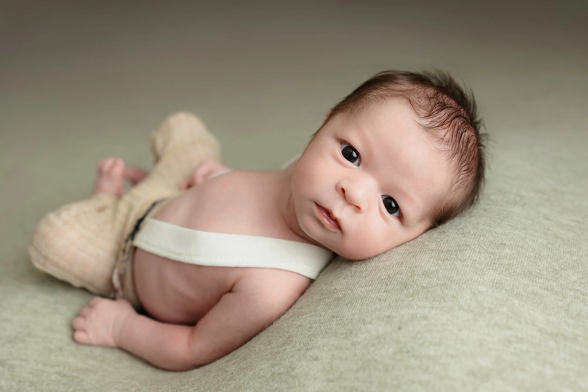 Awake baby boy posing and staring at the camera with a sweet happy look.