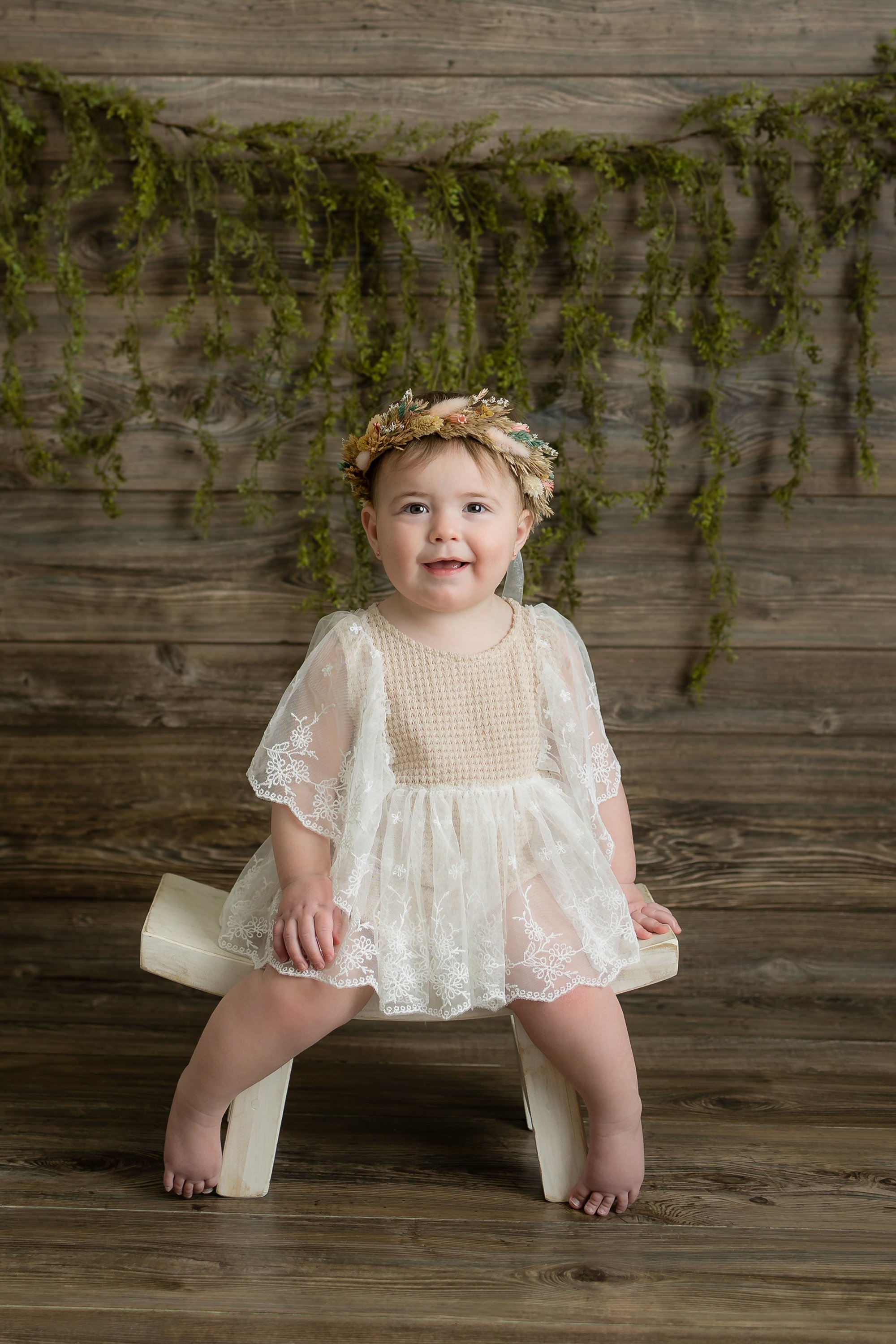 Soft greenery, earthy tones, and a bohemian touch for a beautiful natural milestone portrait.