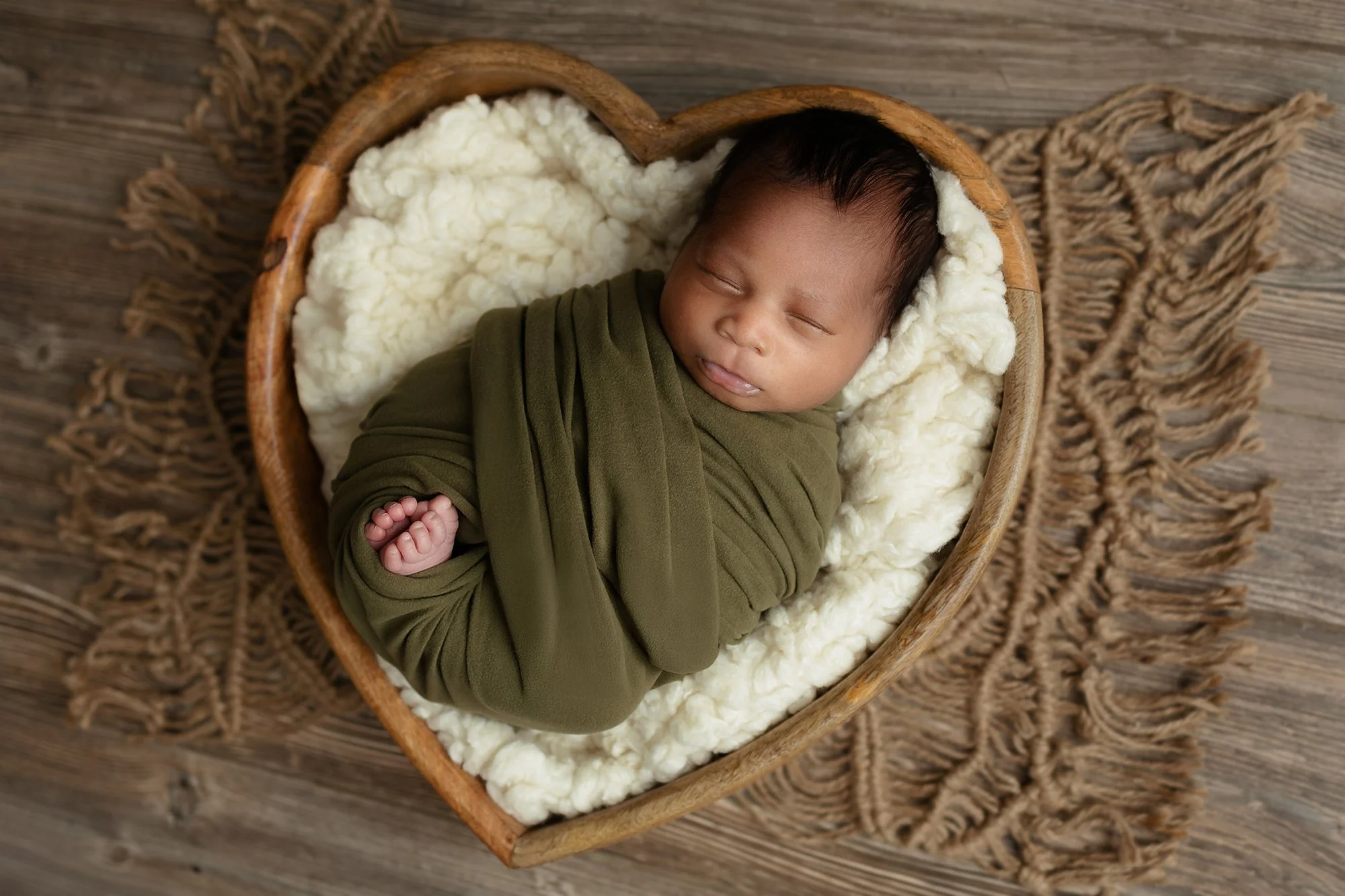 Alexandria, VA Peaceful newborn baby sleeping on a soft, neutral blanket.