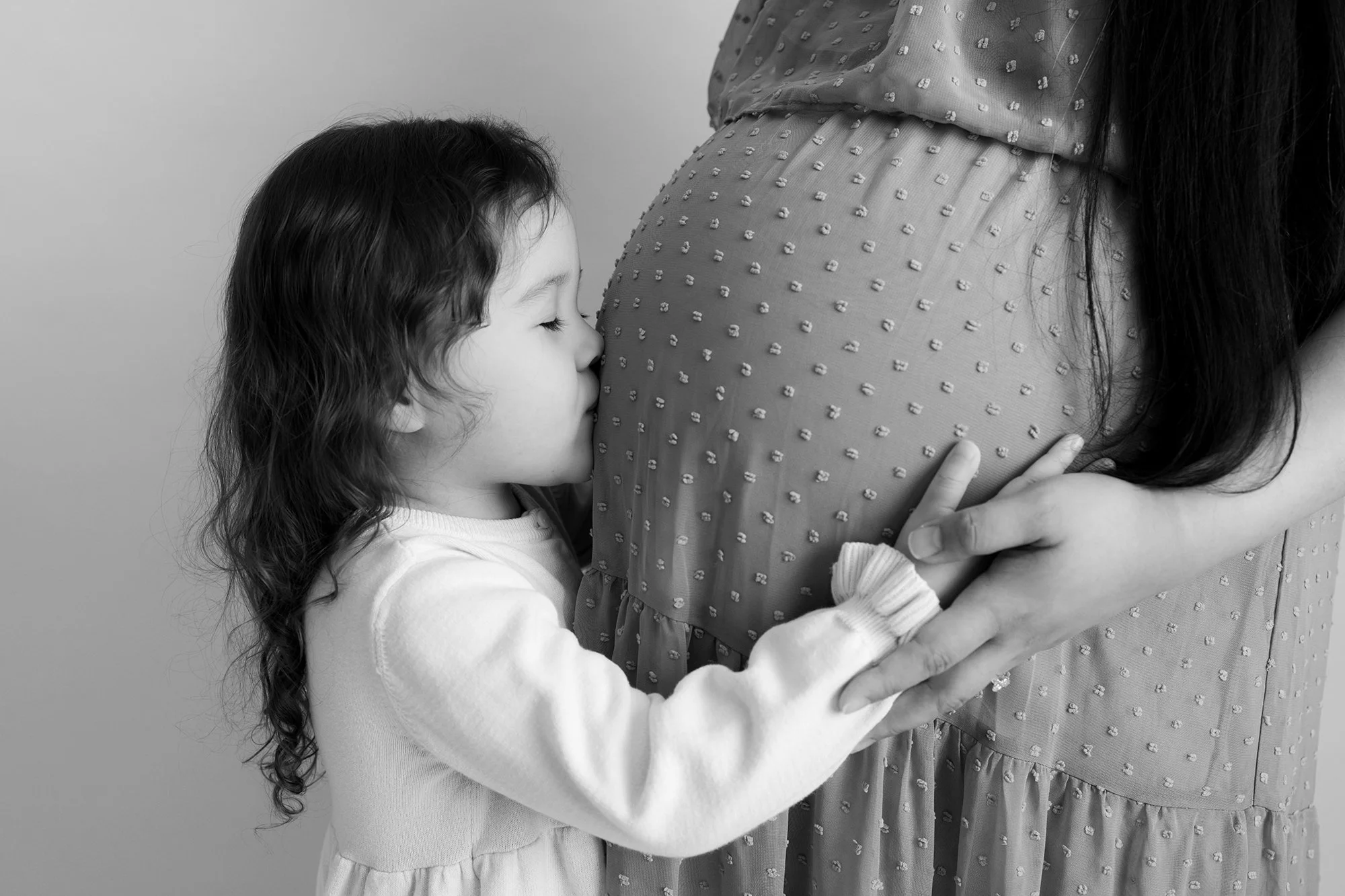 baby kissing mommy's pregnant belly