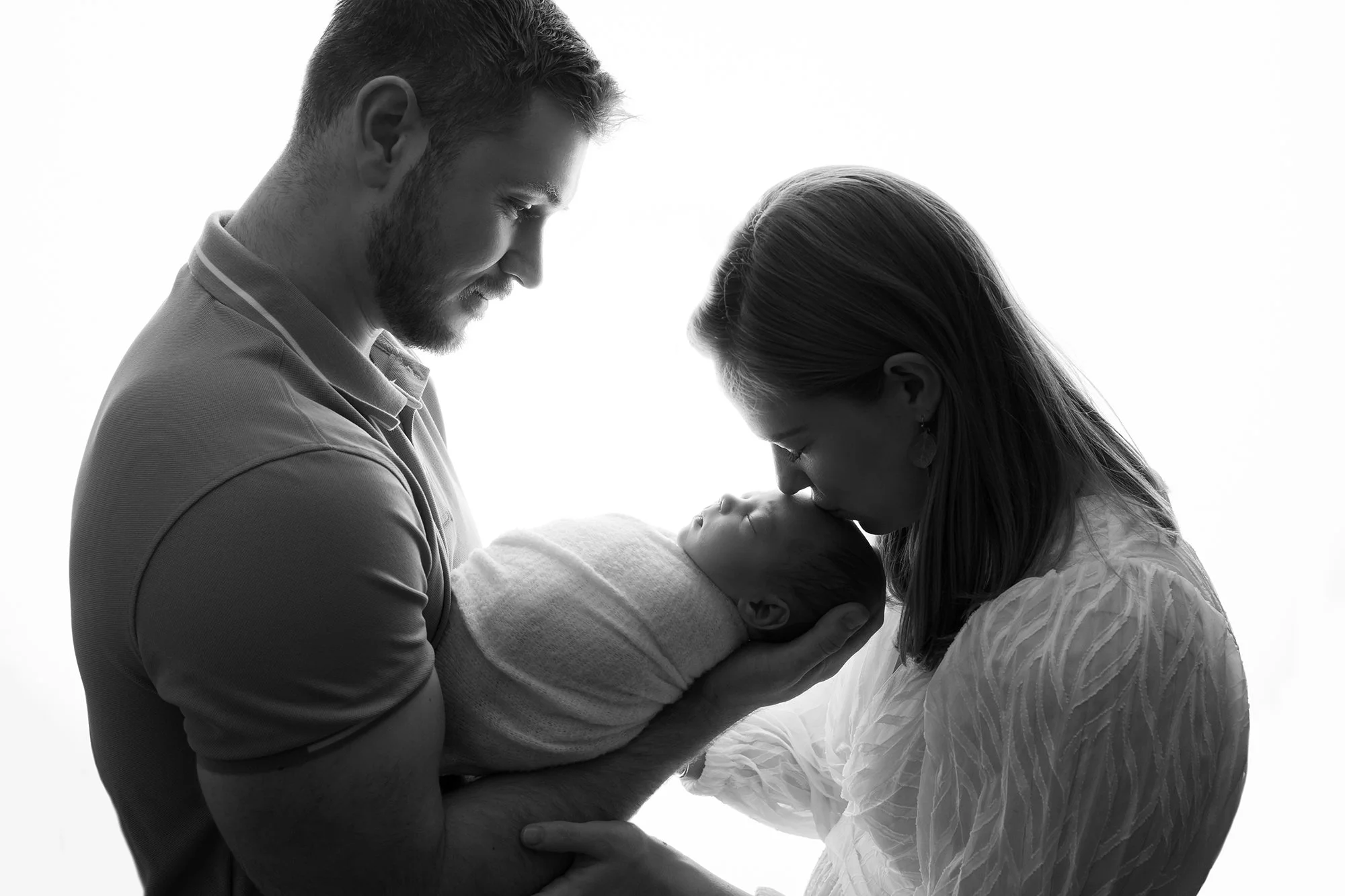 Parents lovingly holding their newborn baby together in Alexandria Virginia