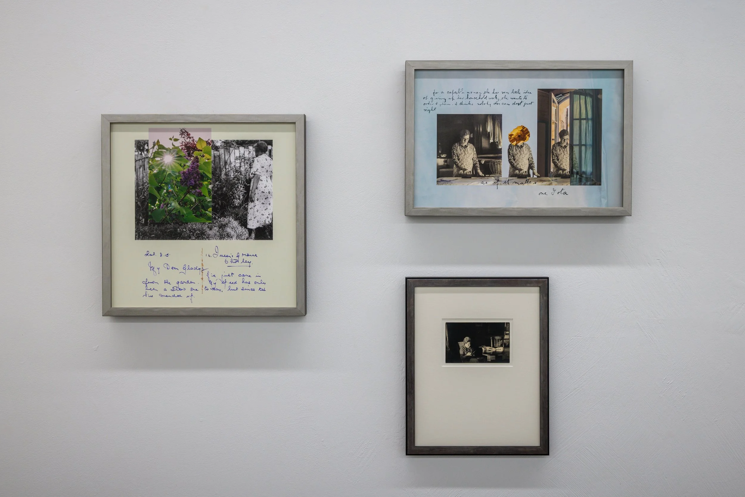 A gallery wall with framed photographs and prints, including black-and-white images of women and handwritten notes, arranged on a plain white wall.
