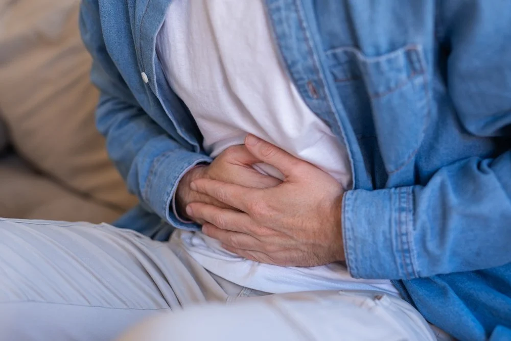 Close up man holding stomach in discomfort | Safer Sacramento