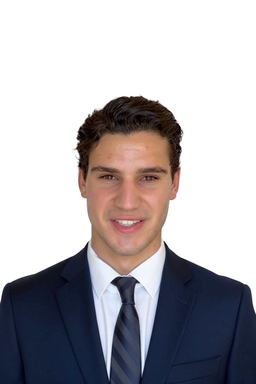 A young man with dark hair, wearing a white dress shirt and a navy blazer, smiling against a white background.