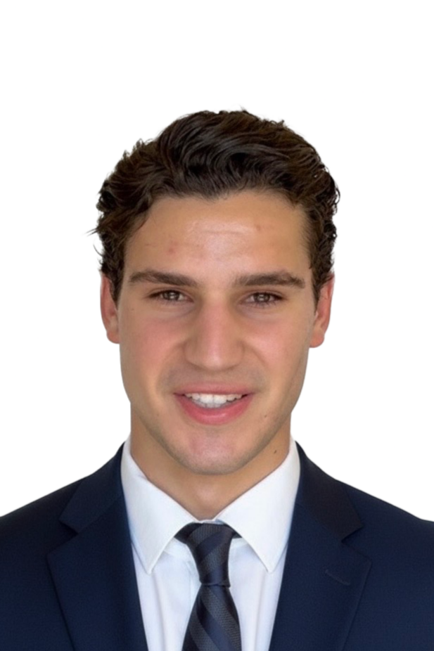 Young man with dark brown hair, wearing a navy suit, white shirt, and striped tie, smiling against a white background.