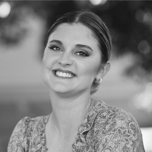 Black and white portrait of a smiling woman with tied-back hair.