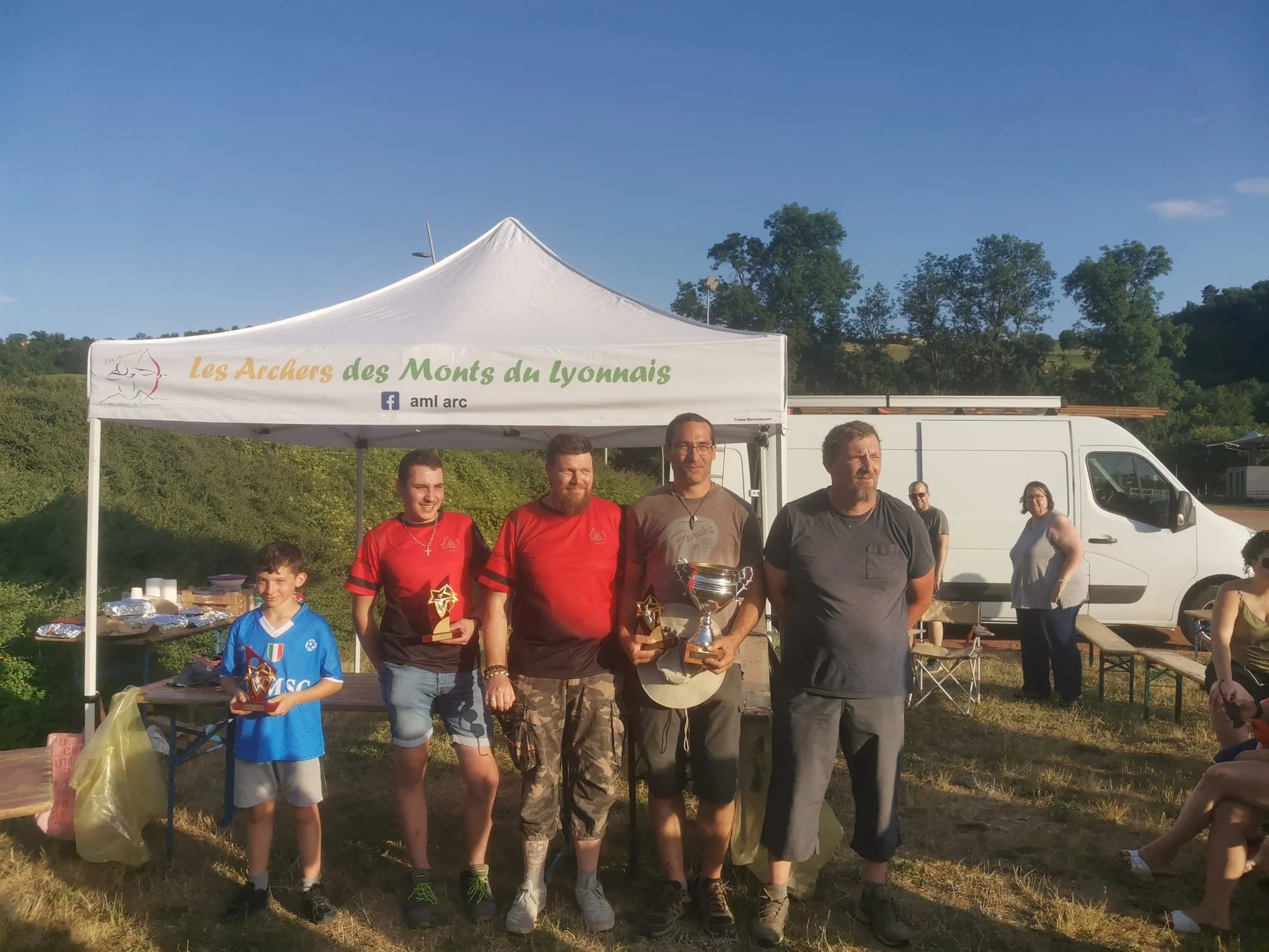 Robin, Loïc, Sylvain et Sébastien, les nouveaux Roys, récupèrent leur trophée des mains du président - Tir du Roy - Juin 2026