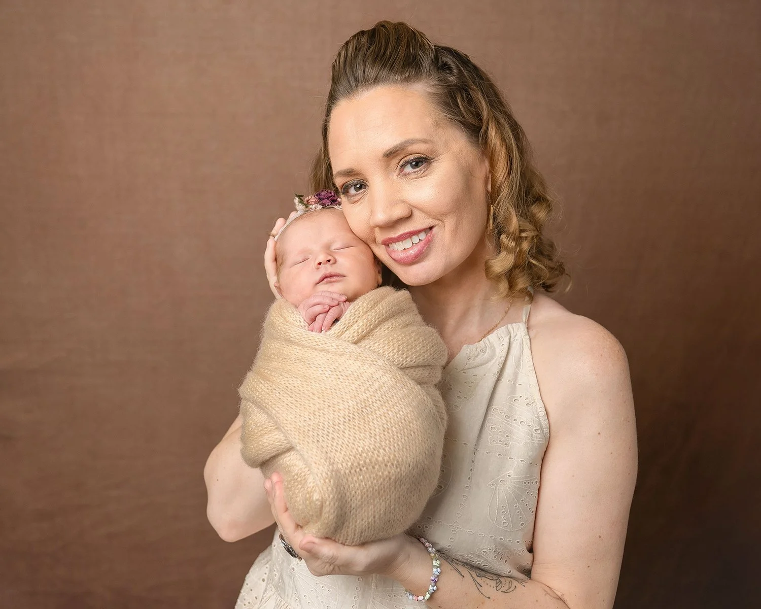 Swaddled newborn baby and mom against a neutral background at Anna Kay Photography in Barrington, RI.