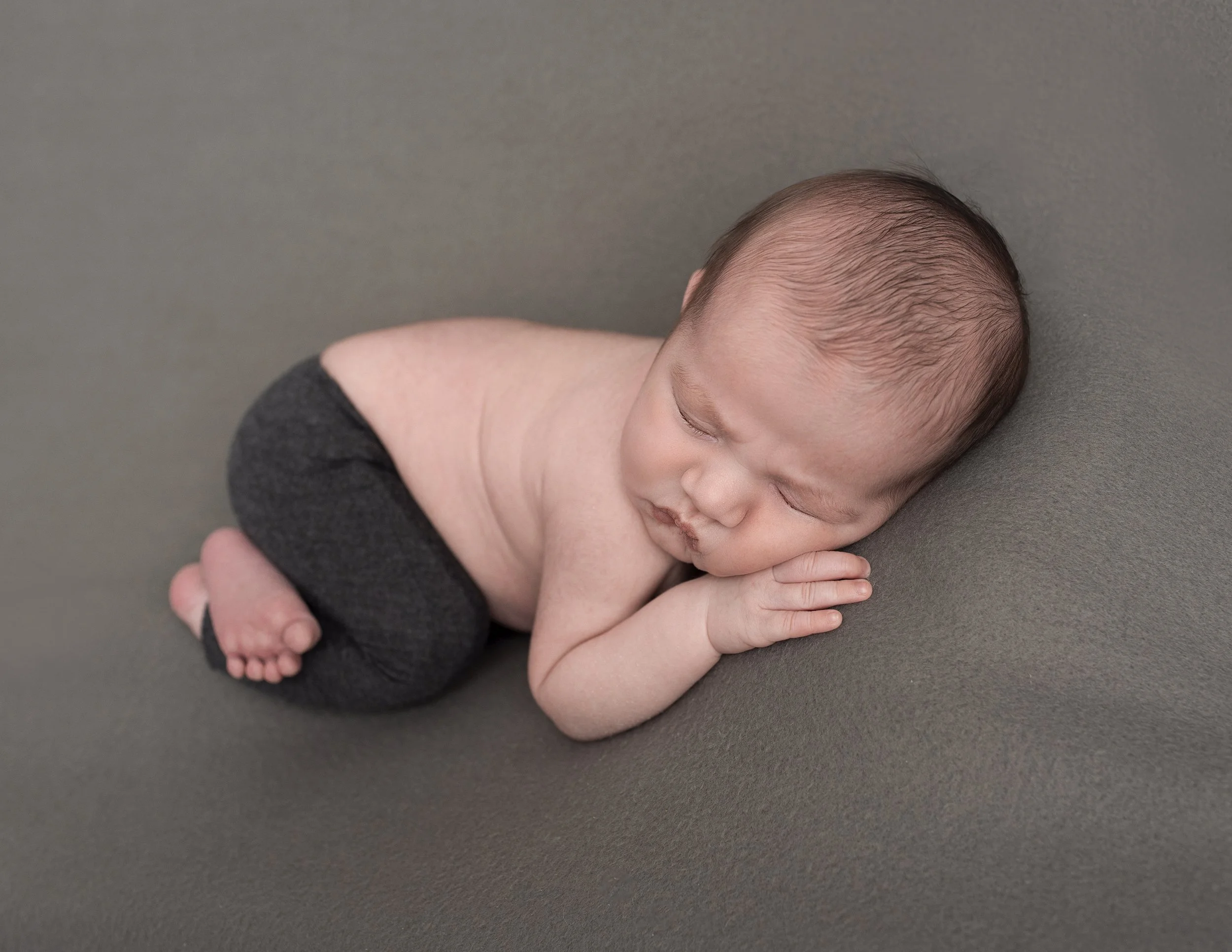 Sleeping newborn posed in professional newborn photography studio
