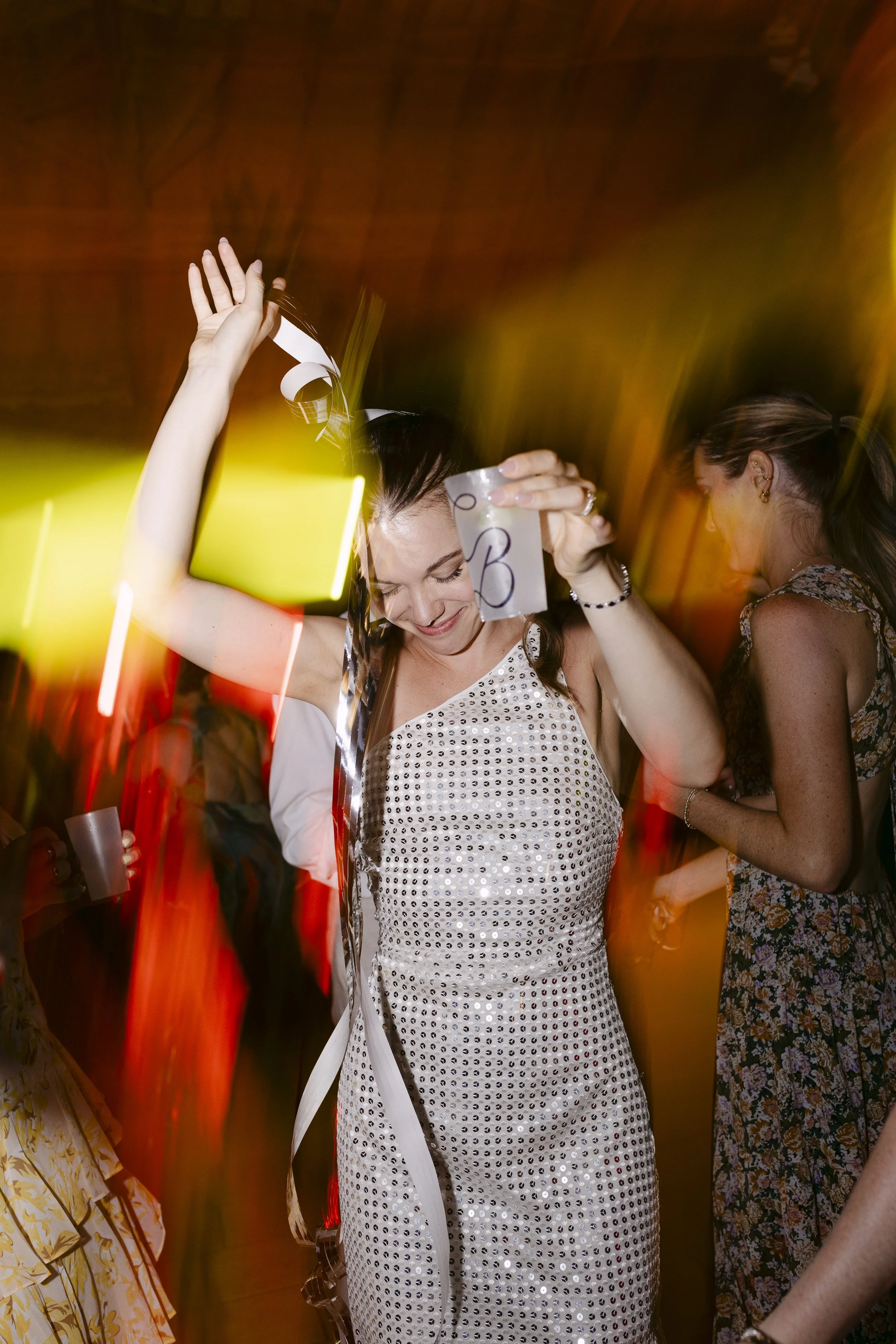 Femme heureuse dansant avec un verre à la main lors d'une fête