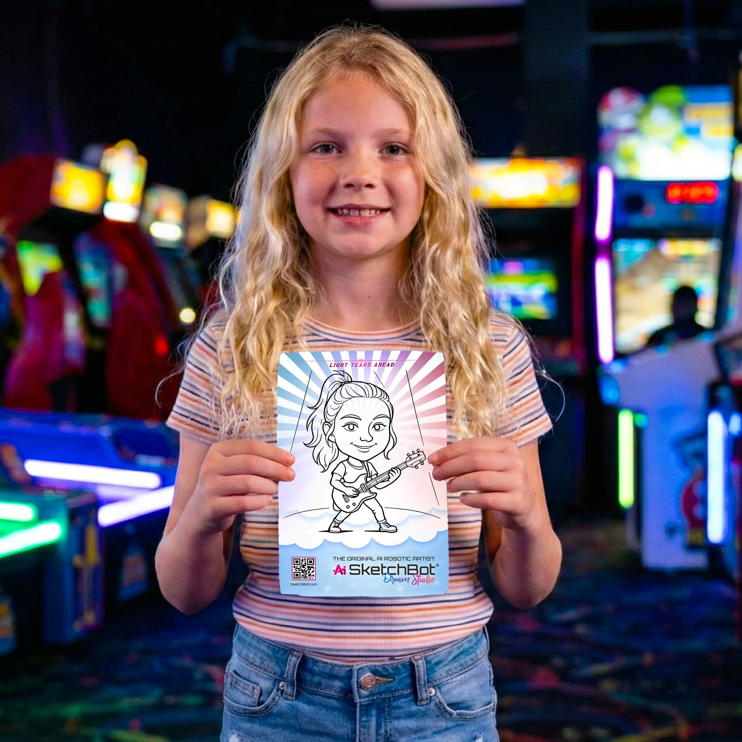 A little girl holding up a sketch of her as a rockstar