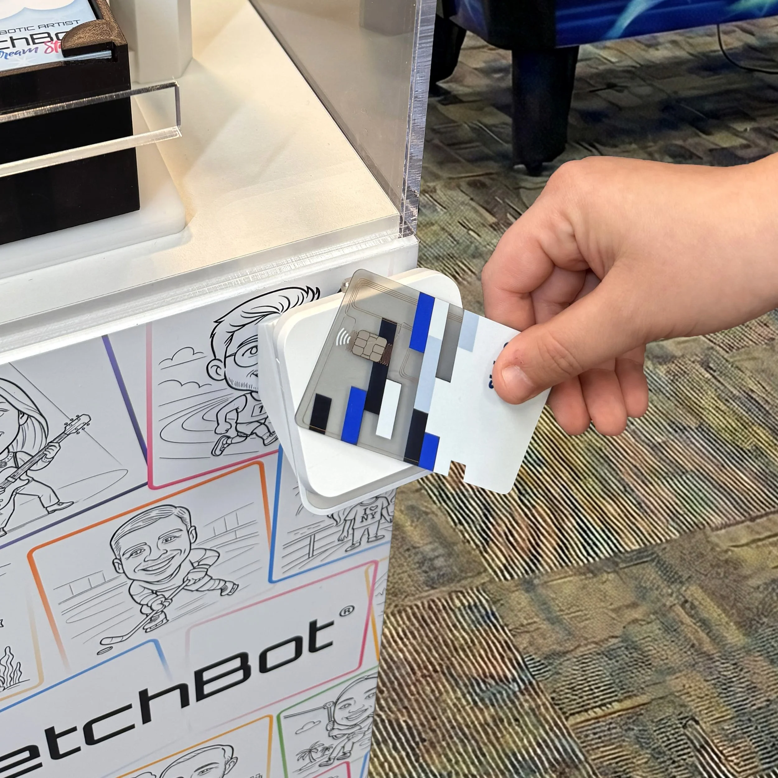 Person tapping their card to pay for their personalized sketch by SketchBot Pro