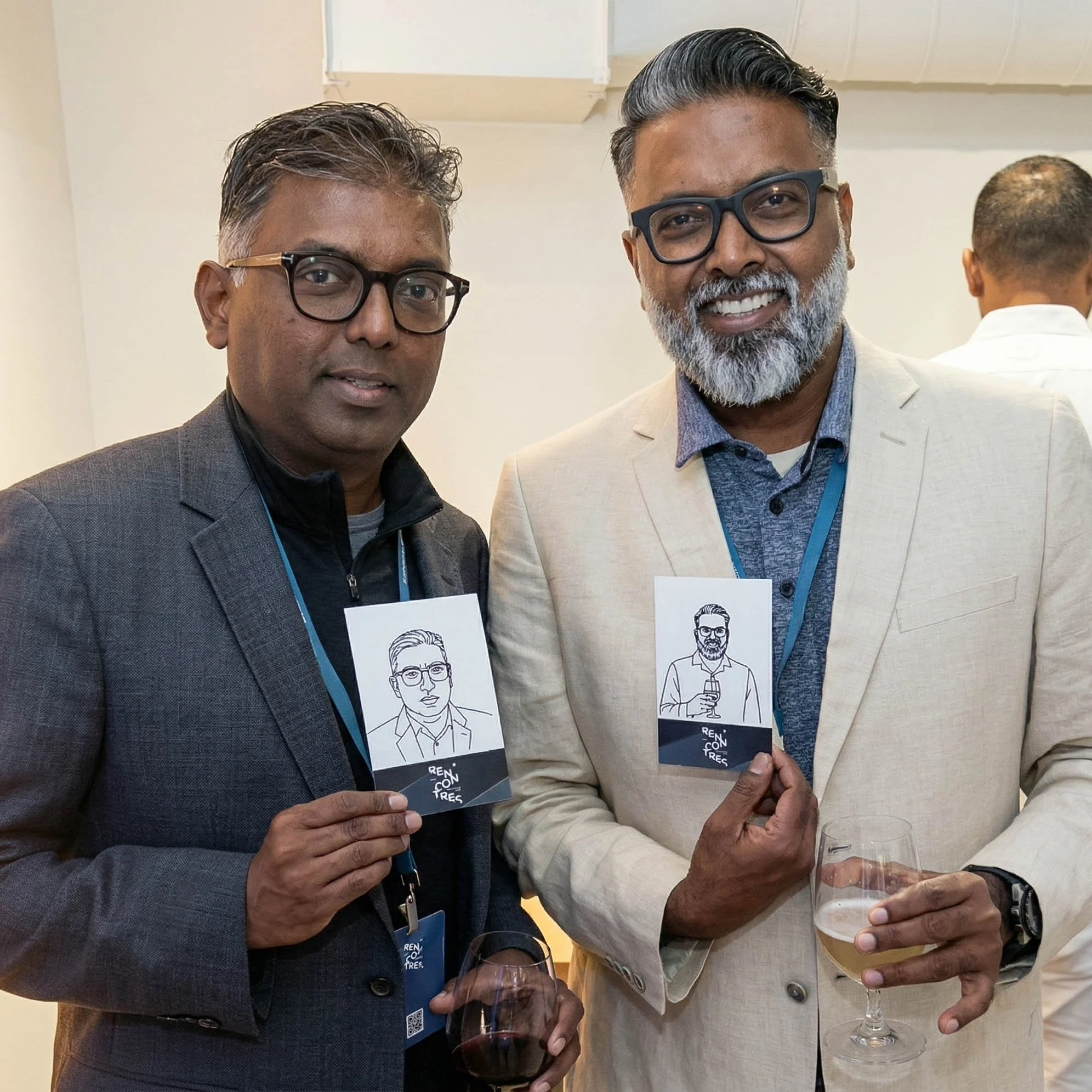Two attendees holding up their robotic drawn portraits