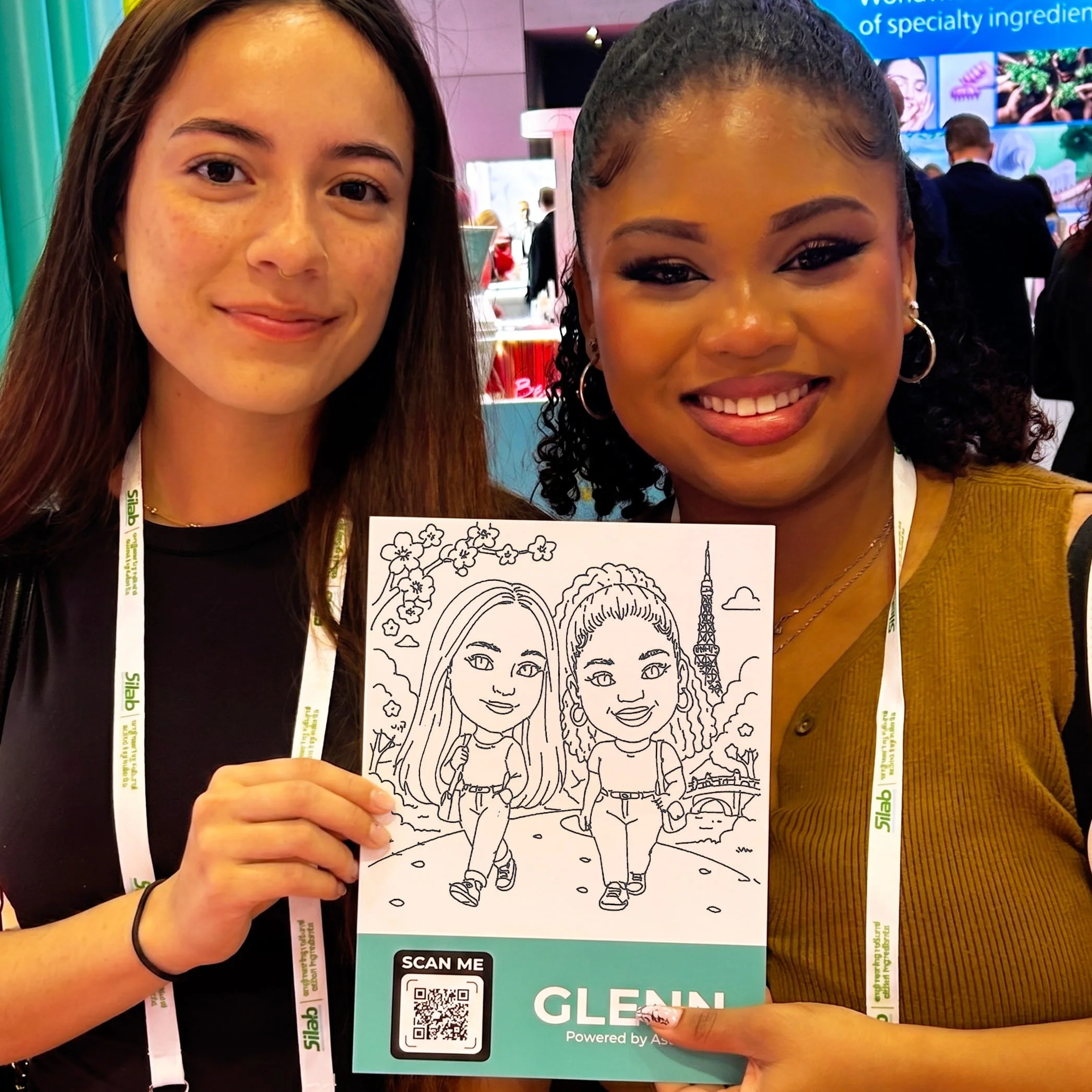 Two girls holding up a robotic drawn sketch of both of them