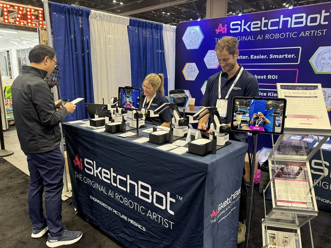 Ai SketchBot Team interacting with an attendee at IAAPA