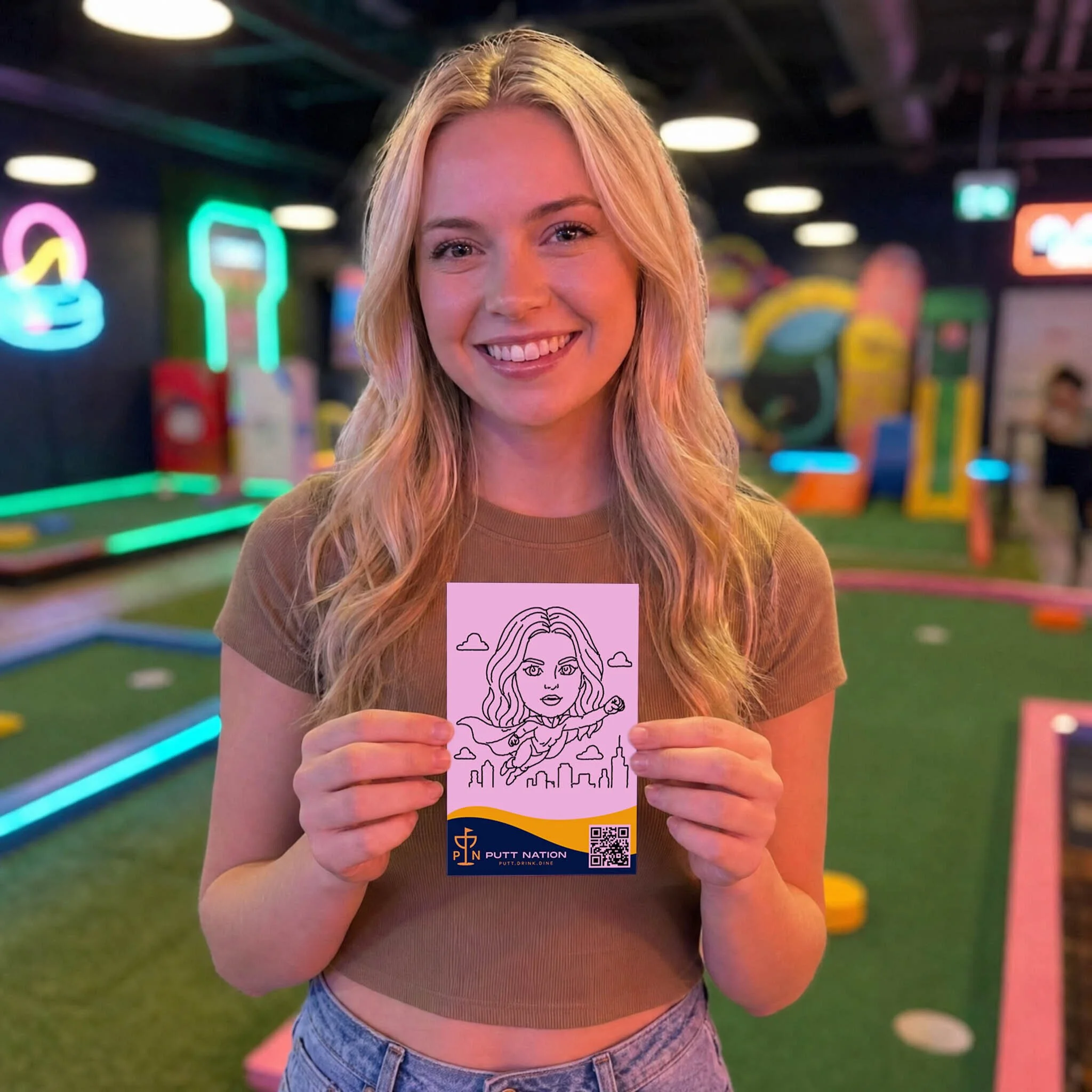 A girl holding up her sketch drawn by SketchBot at Putt Nation